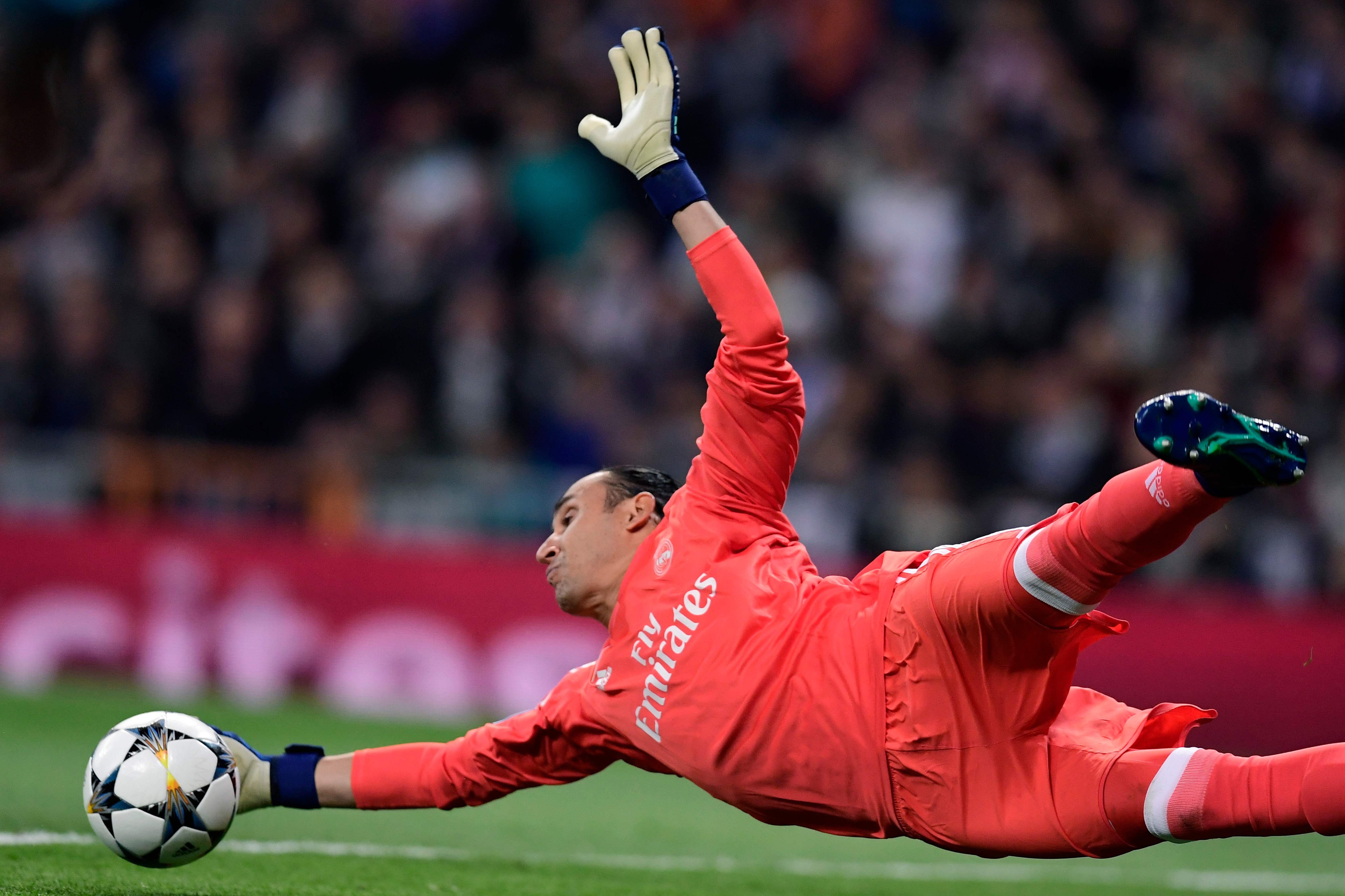 Real Madrid's Costa Rican goalkeeper Keylor Navas dives for the ball during the UEFA Champions League quarter-final second leg football match between Real Madrid CF and Juventus FC at the Santiago Bernabeu stadium in Madrid on April 11, 2018. / AFP PHOTO / JAVIER SORIANO