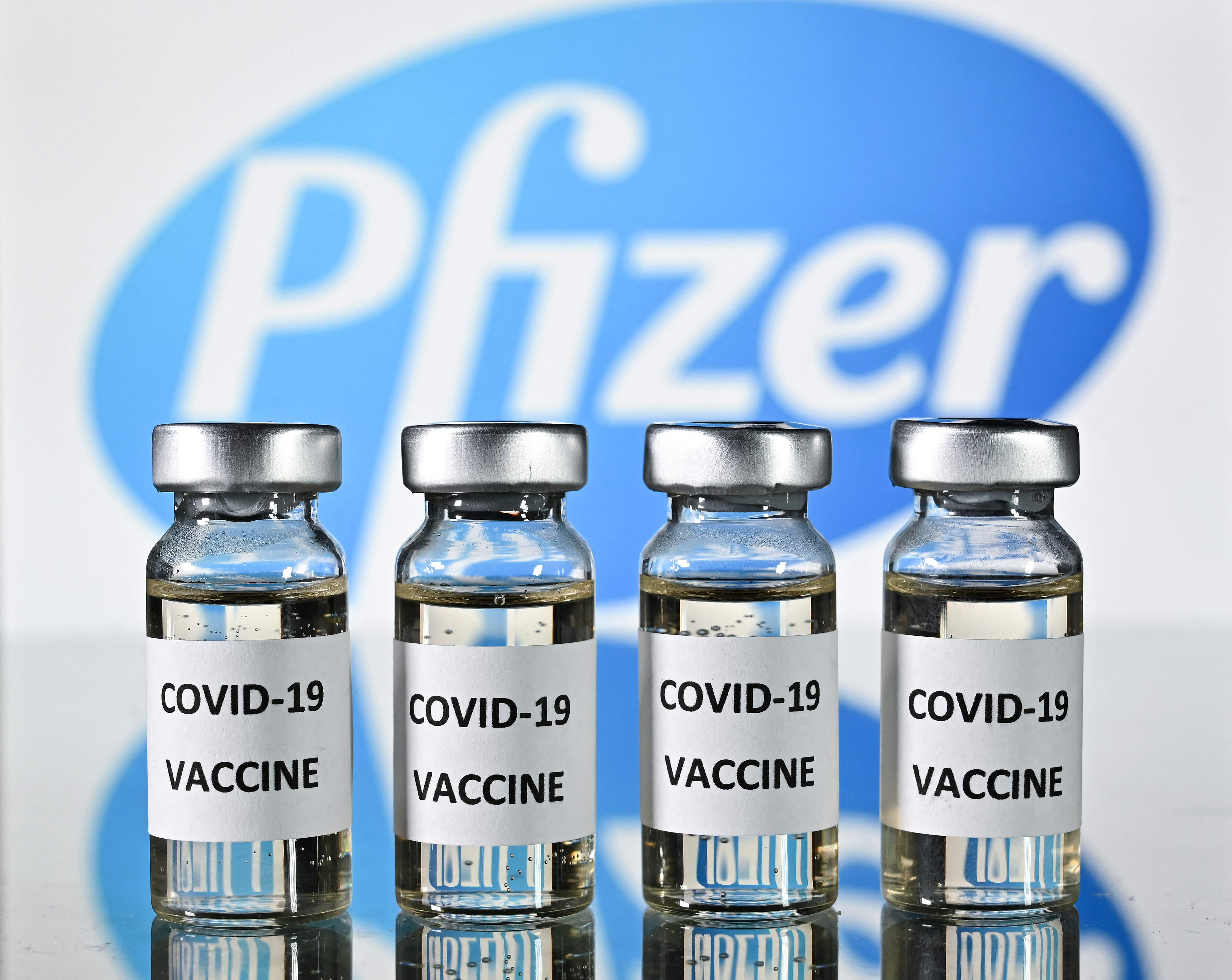 (FILES) This file photo illustration picture shows vials with Covid-19 Vaccine stickers attached, with the logo of US pharmaceutical company Pfizer, on November 17, 2020. - The administration of President Joe Biden is buying 500 million doses of the Pfizer-BioNTech Covid-19 vaccine to distribute among other countries, US media reported on June 9, 2021 citing people familiar with the matter. Biden will make the formal announcement at the G-7 meeting in Britain this week, the Washington Post and New York Times said. (Photo by JUSTIN TALLIS / AFP)