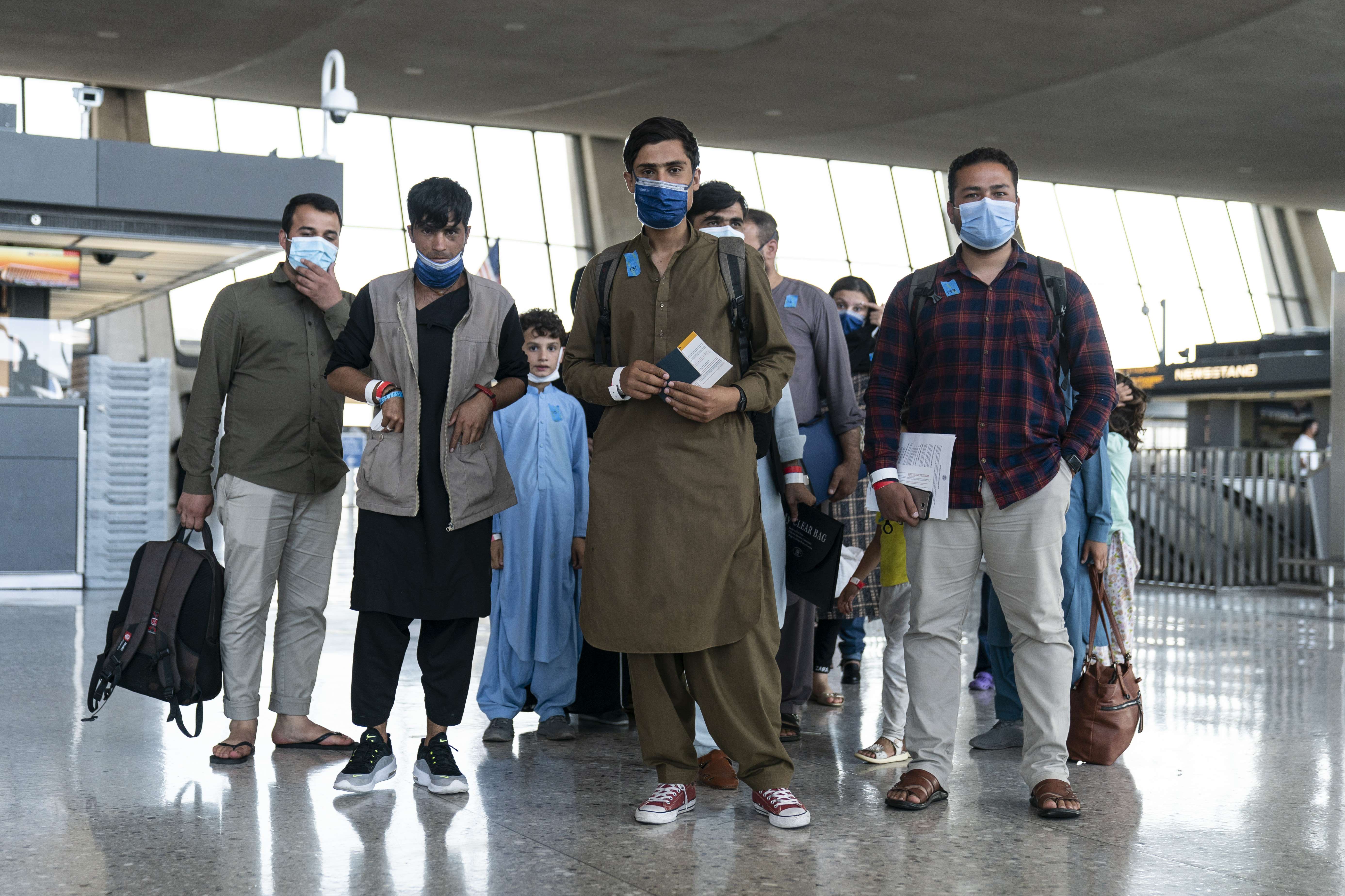 DULLES, VA - AUGUST 24: Afghan families pause as they walk to a bus that will take them to a refugee processing center at Dulles International Airport on August 24, 2021 in Dulles, Virginia. According to the U.S. State Department, between Sunday morning and Monday morning, 10,400 people were evacuated from Kabul on military flights and approximately 5,900 more people were evacuated on 61 coalition aircraft. Joshua Roberts/Getty Images/AFP
== FOR NEWSPAPERS, INTERNET, TELCOS & TELEVISION USE ONLY ==