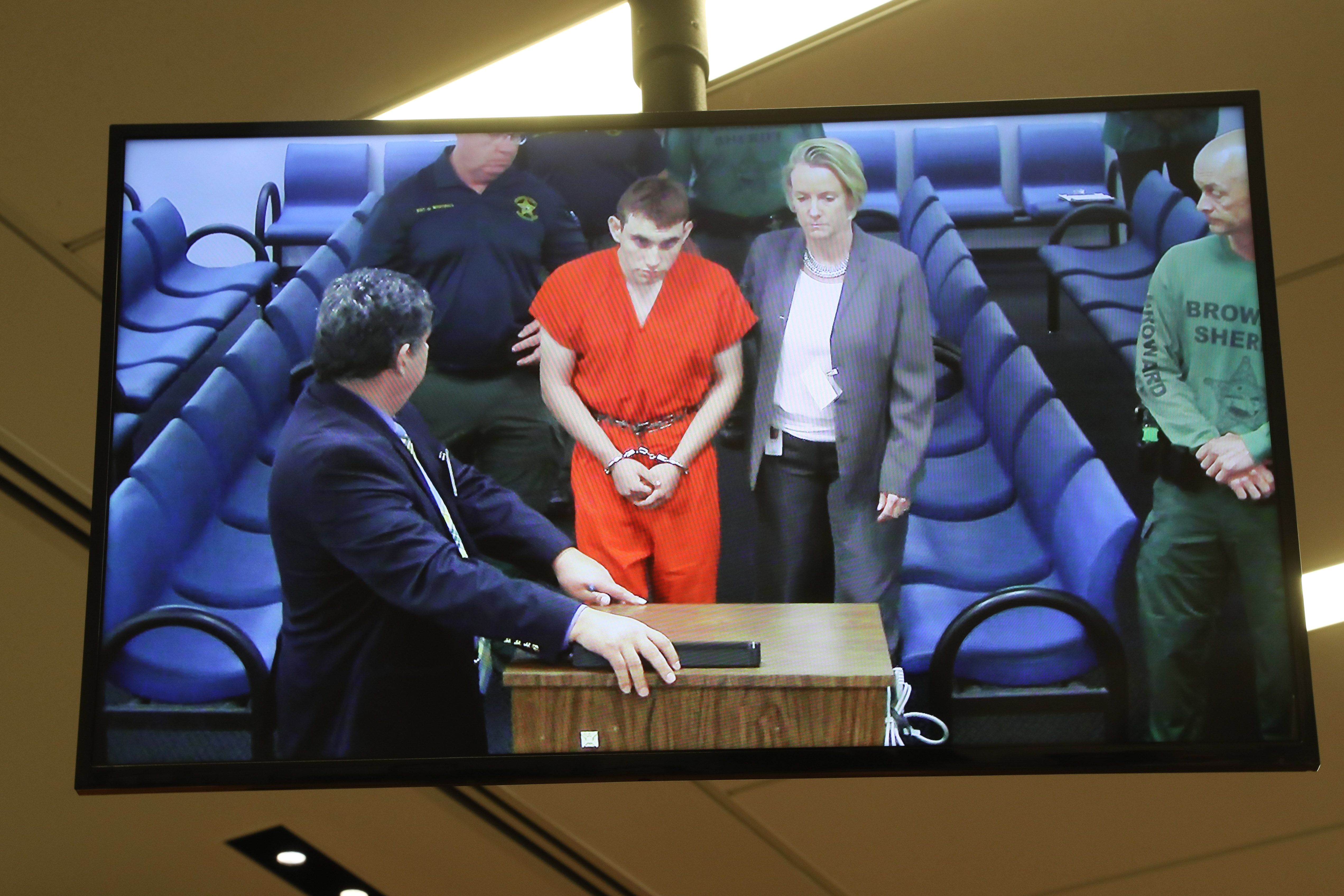 Hector Romero Asst. Public Defender(L) and Melisa McNeill, Public Defender (R) are seen on screen at the first appearance court for high school shooting suspect Nikolas Cruz(C) on February 15, 2018 at Broward County Court House in Fort Lauderdale, Fla.
The heavily armed teenager who gunned down students and adults at a Florida high school was charged Thursday with 17 counts of premeditated murder, court documents showed. Nikolas Cruz, 19, killed fifteen people in a hail of gunfire at Marjory Stoneman Douglas High School in Parkland, Florida. Two others died of their wounds later in hospital, the sheriff's office said.
/ AFP PHOTO / POOL / Susan STOCKER