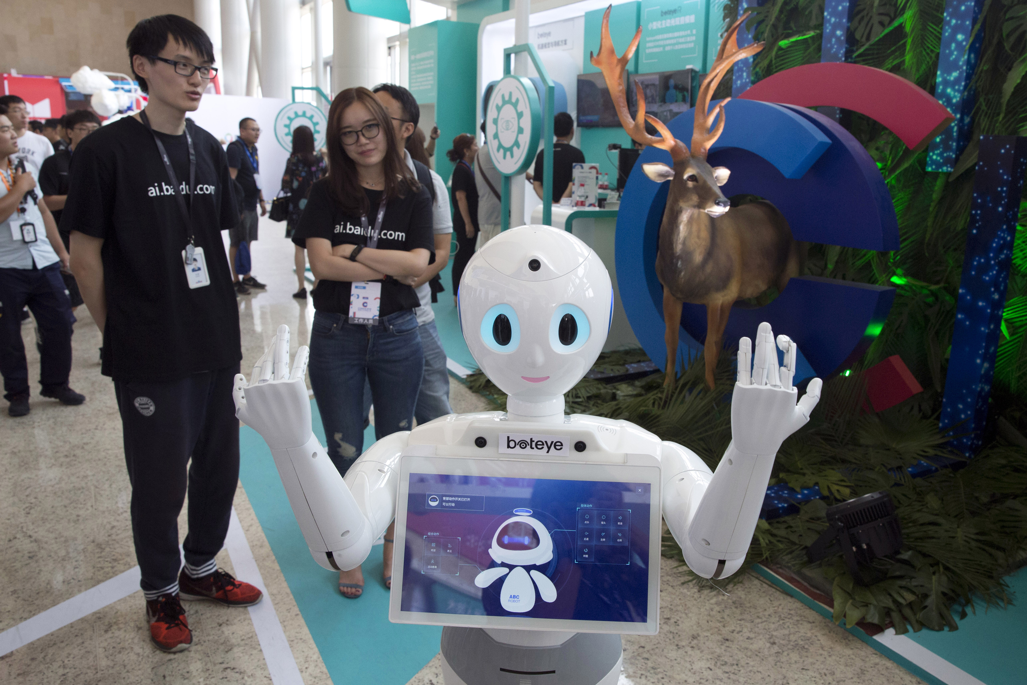 In this July 4, 2018, photo, a robot from Chinese search company Baidu welcomes visitors to a developer event in Beijing, China. The Trump administration contends China has deployed predatory tactics in a push to overtake U.S. technological dominance. These tactics include cyber-theft and requiring American companies to hand over technology in exchange for access to China's market. Chinese officials reject accusations of theft and say no foreign company is obligated to share technology. (AP Photo/Ng Han Guan)