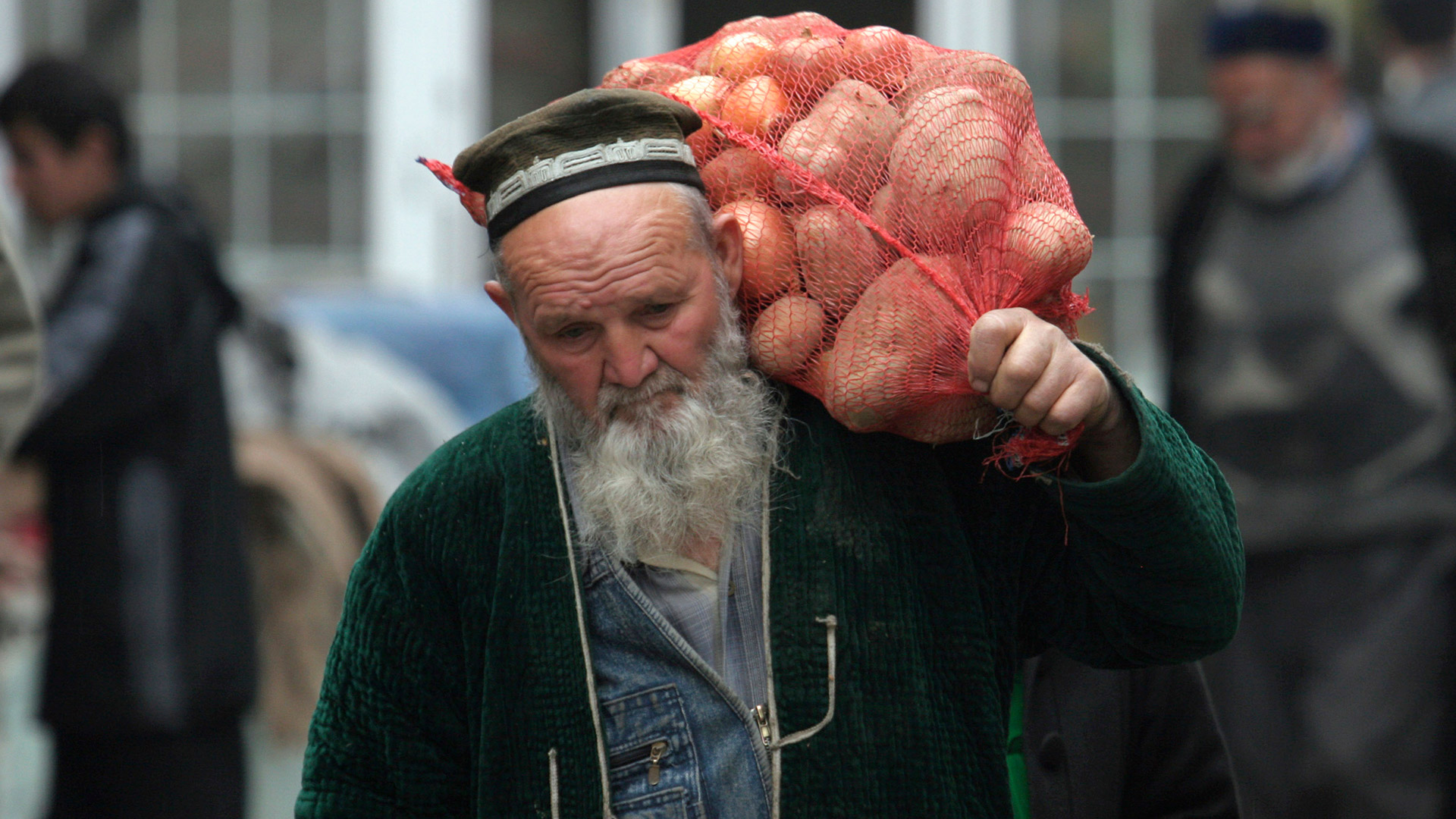 A man carries a sack of potatoes at a market in Dushanbe February 23, 2009. Picture taken February 23, 2009.  Plagued by poverty, rampant crime and now collapsing incomes, Tajikistan risks turning into a failed state -- a setback for the West which sees it as a new supply transit point for U.S. troops fighting in neighbouring Afghanistan. To match feature TAJIKISTAN-CRISIS/  REUTERS/Nozim Kalandarov (TAJIKISTAN POLITICS BUSINESS SOCIETY)