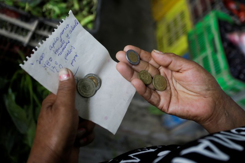 file image.  Elena Rodríguez carries a list of products and money to shop for her soup kitchen as she works in Pamplona Alta, a low-income neighborhood on the outskirts of the Peruvian capital where high food prices make animal protein unattainable.  Citizens, in Lima, Peru, April 11, 2022. Photo taken April 11, 2022. REUTERS/Daniel Bisrel