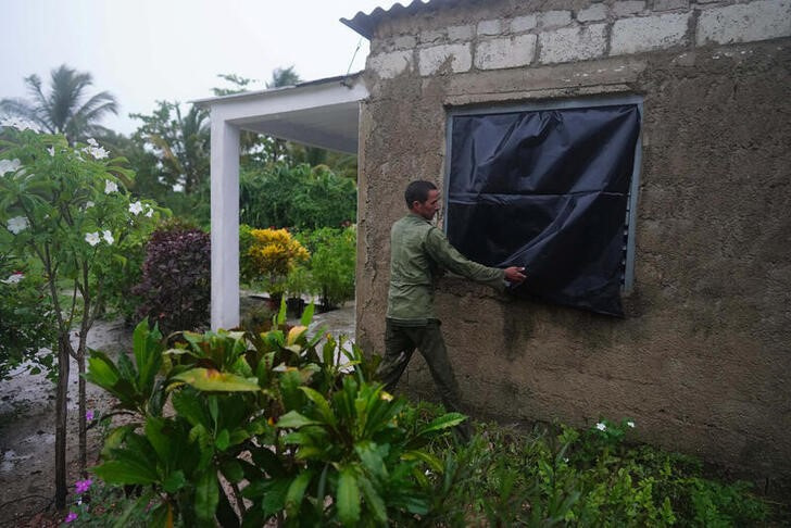 El granjero Cito Braga protege una ventana de su casa antes de la llegada del huracán Ian a Coloma, Cuba. 26 septiembre 2022. REUTERS/Alexandre Meneghini