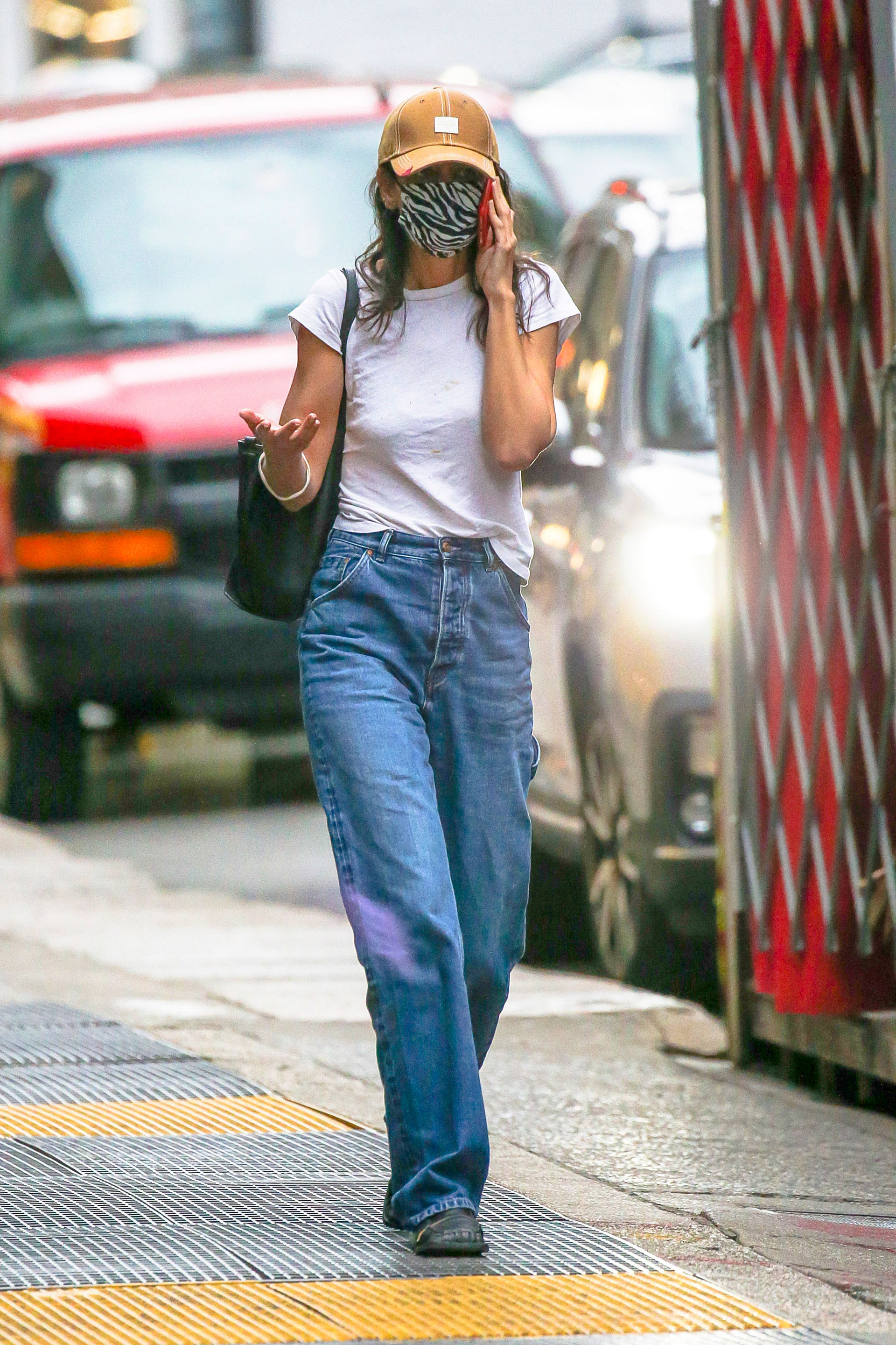Katie Holmes fue fotografiada mientras caminaba por el barrio Soho de Nueva York. La actriz intentó pasar desapercibida con su look: si bien lució un jean y una remera blanca clásica, sumó un tapabocas estampado en animal print y una gorra (Fotos: The Grosby Group)