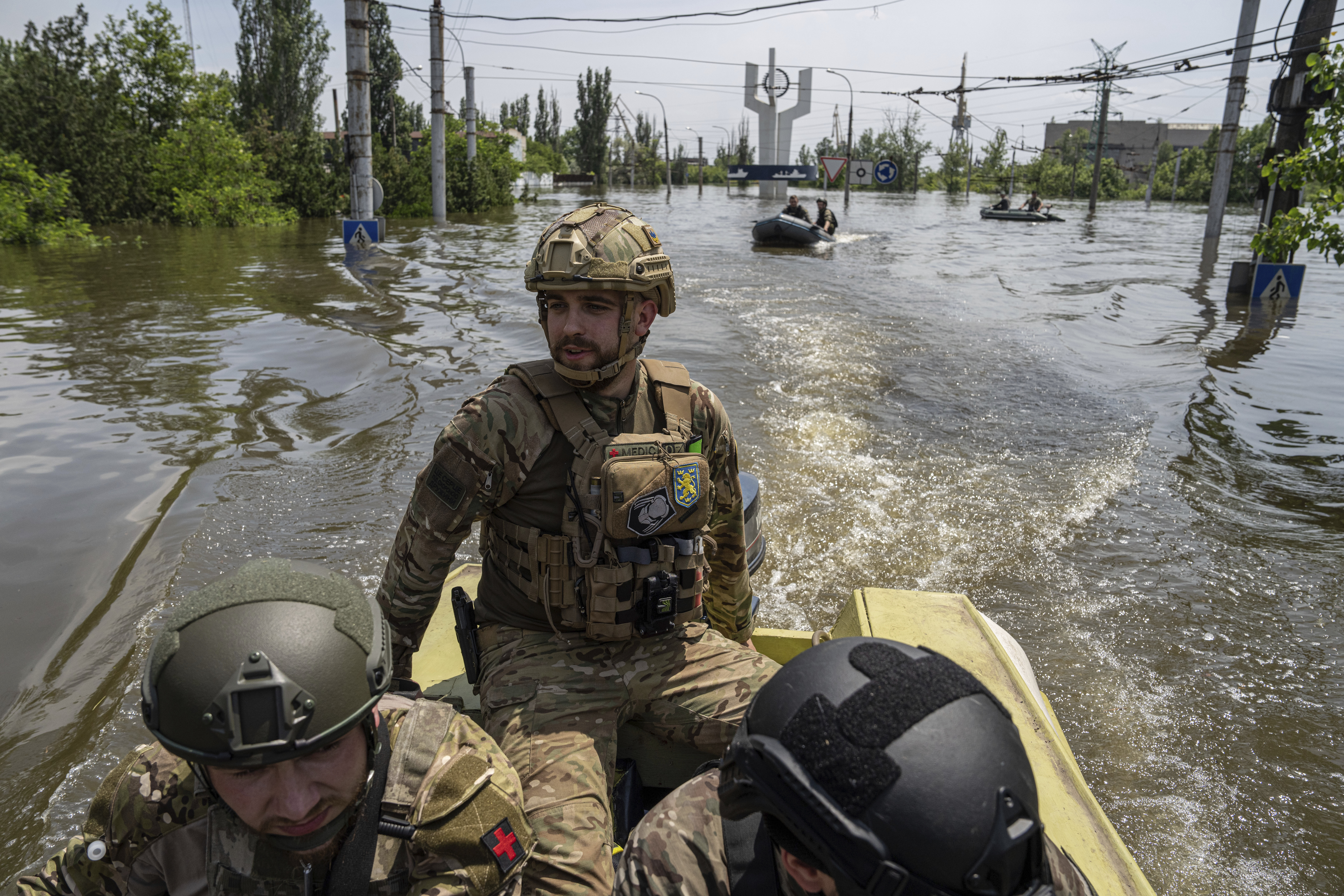 Soldados ucranianos, a bordo de una lancha rápida en un vecindario inundado en Jersón, Ucrania, el 8 de junio de 2023. Muchas embarcaciones pequeñas, con rescatistas y soldados a bordo, cruzan desde zonas controladas por Ucrania, en la orilla oeste del río Dniéper, para rescatar a civiles desesperados varados en tejados, áticos y otras zonas altas. (AP Foto/Evgeniy Maloletka)