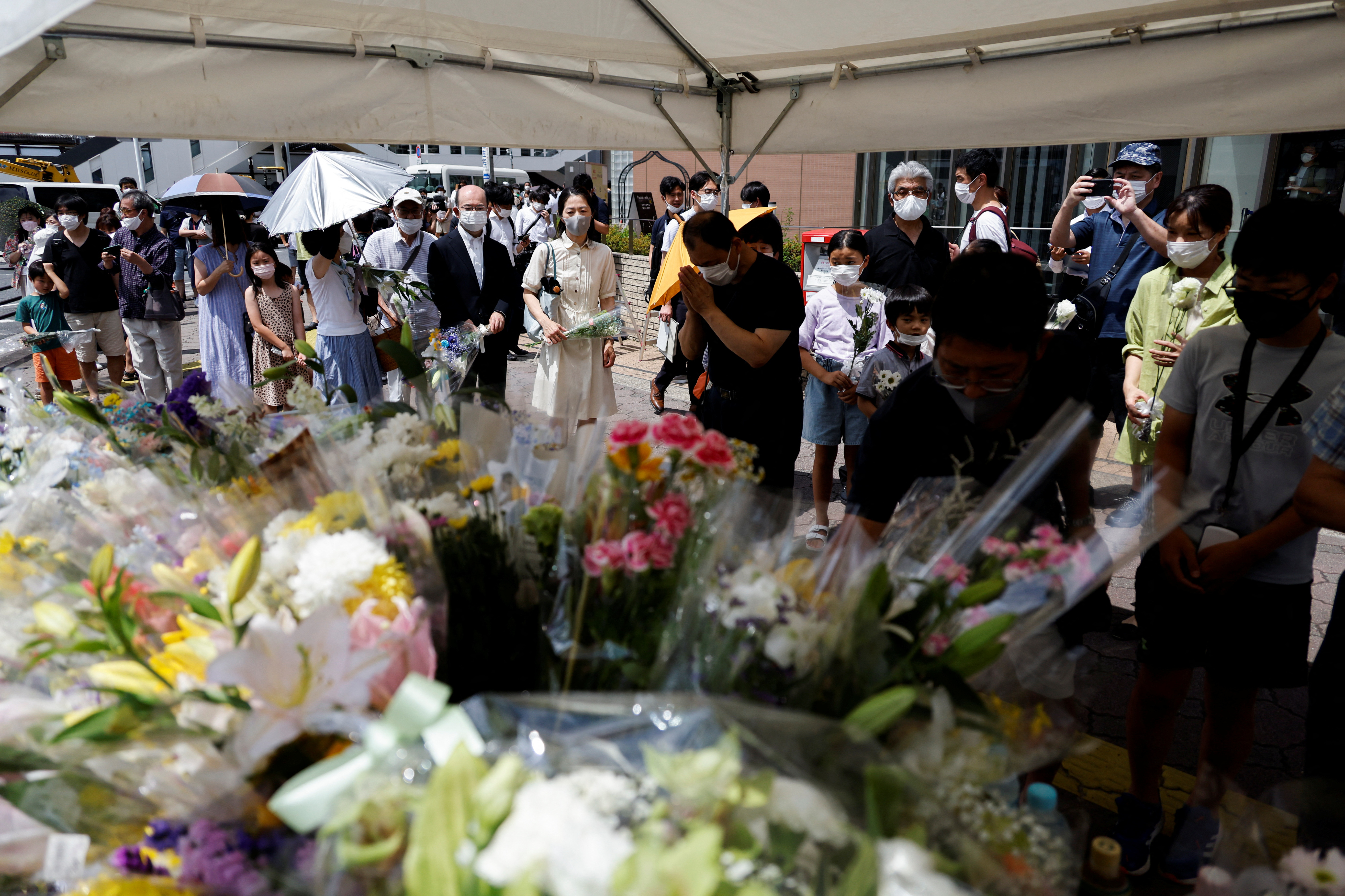 Algunas personas dejaron flores y oraron en el lugar donde ocurrió el ataque contra Abe