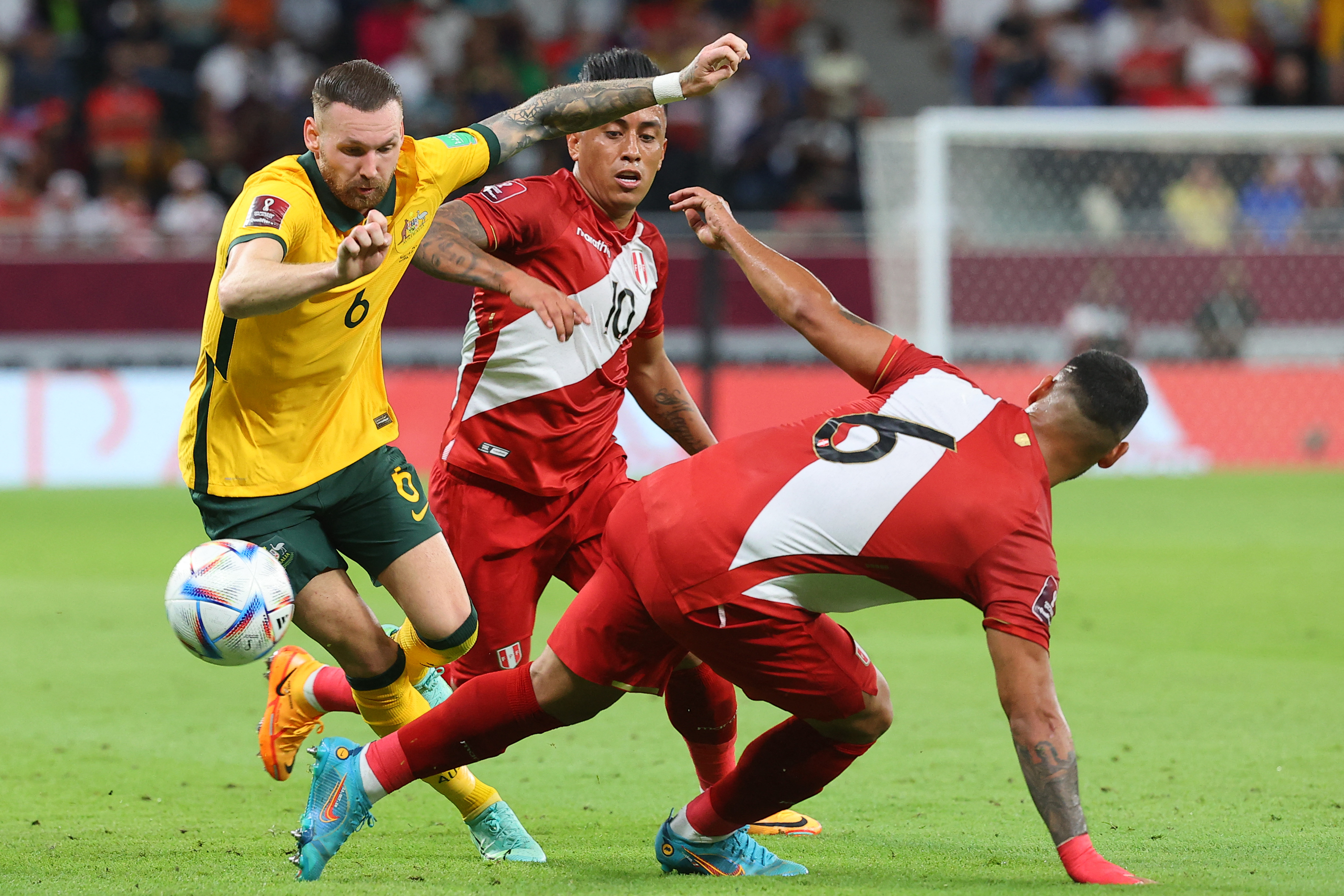 Australia's forward Martin Boyle (L) is tackled by Peru's defender Miguel Trauco (R) during the FIFA World Cup 2022 inter-confederation play-offs match between Australia and Peru on June 13, 2022, at the Ahmed bin Ali Stadium in the Qatari city of Ar-Rayyan. (Photo by KARIM JAAFAR / AFP)