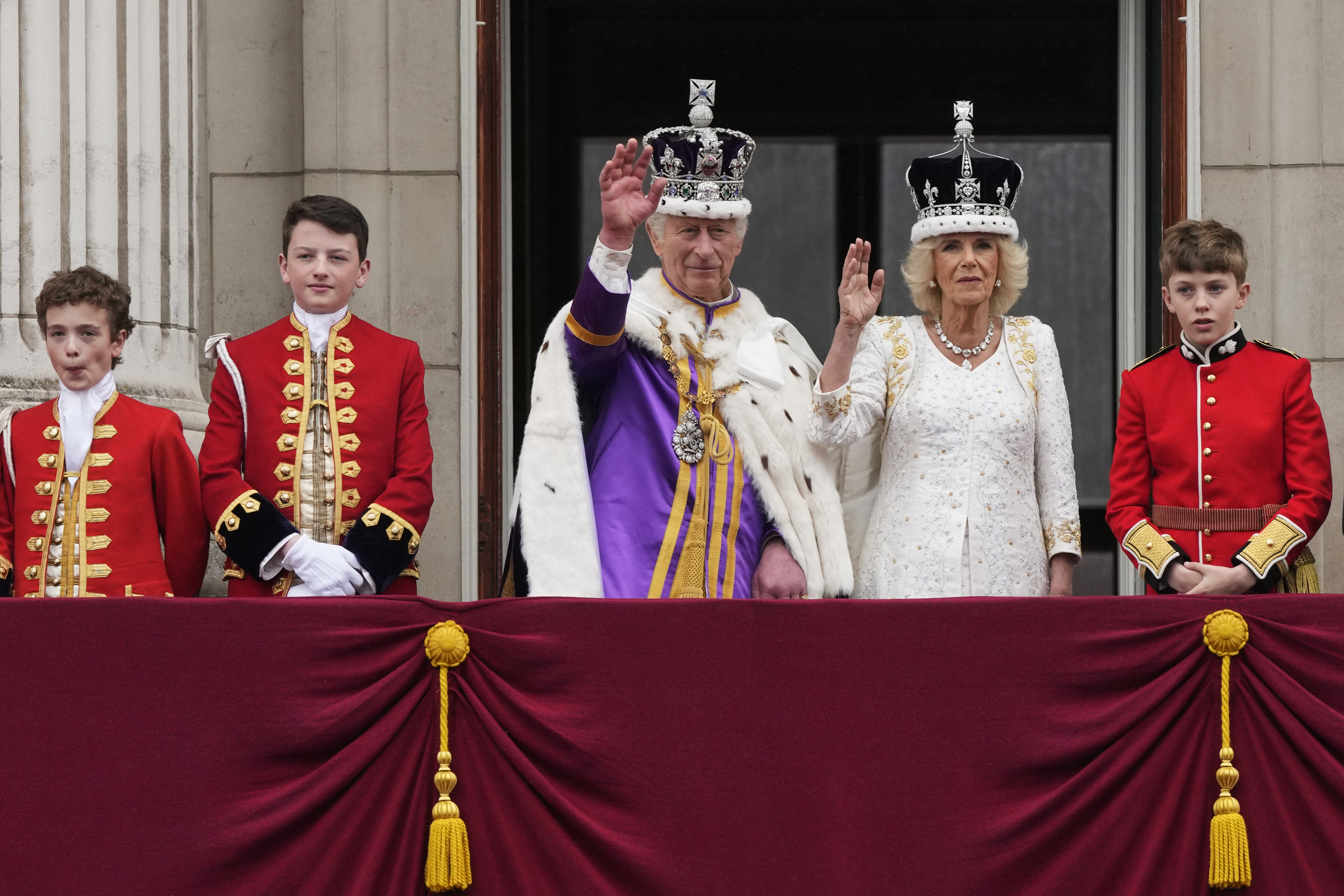 El rey Carlos III y la reina Camila saludan a la multitud desde el balcón del Palacio de Buckingham tras la ceremonia de coronación en Londres (AP Foto/Frank Augstein)