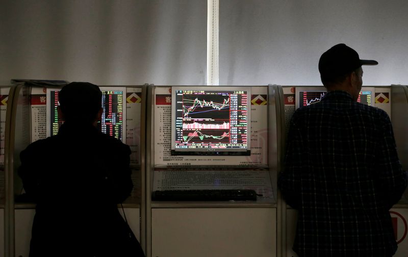 FOTO DE ARCHIVO: Inversores comprueban los precios de las acciones en una oficina de valores en Beijing, China (REUTERS/Jason Lee)