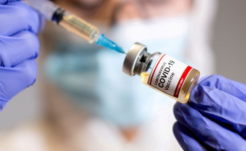Una mujer sostiene una jeringa médica y un frasco etiquetado "Vacuna Coronavirus COVID-19" (REUTERS/Dado Ruvic)