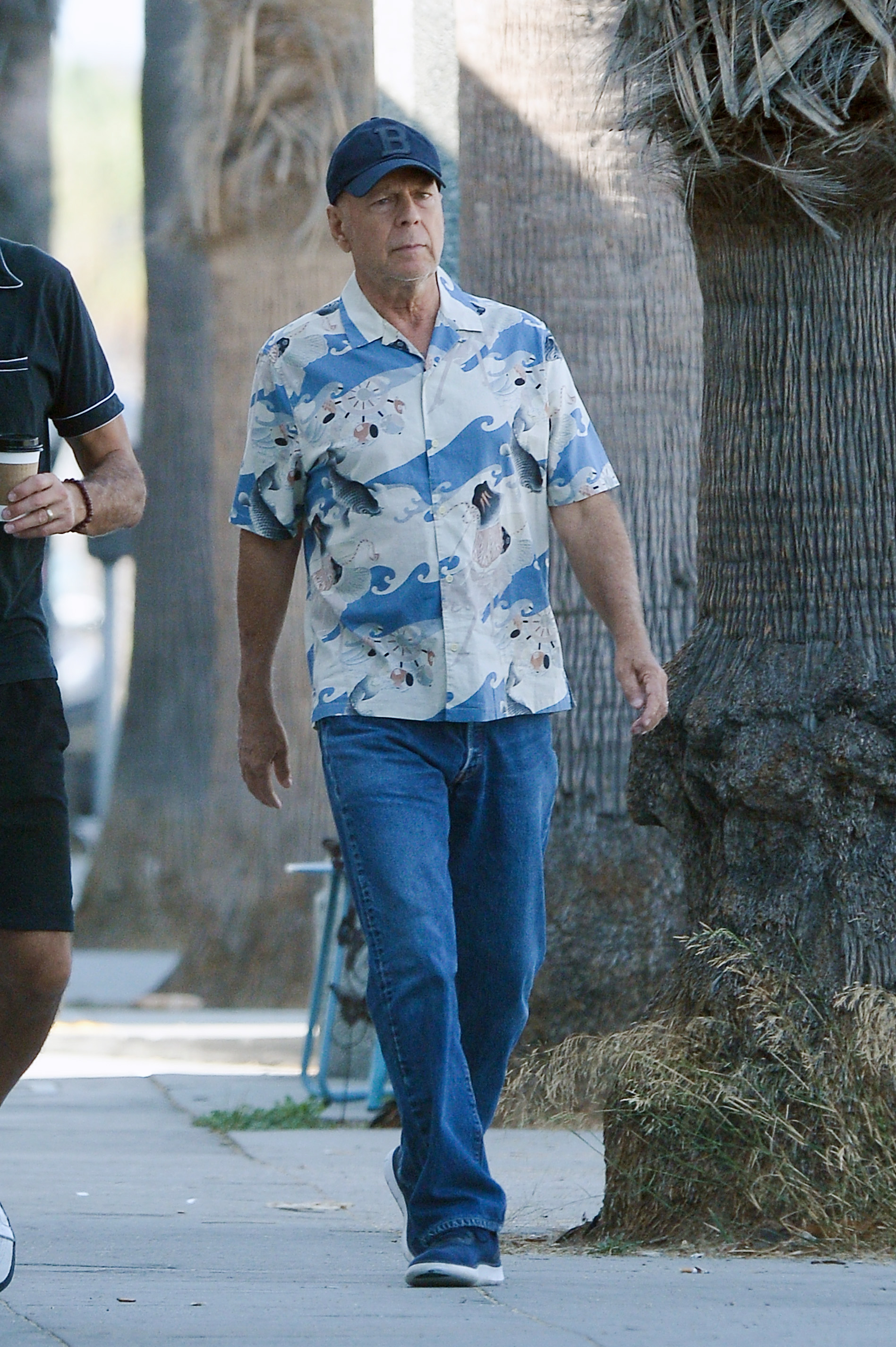 Super relajado Bruce Willis salió a tomar un café con un amigo en Los Ángeles y usó jeans, gorra y camisa hawaiana celeste