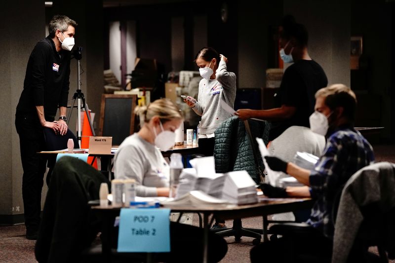 Trabajadores de las mesas electorales procesando los votos en el Conteo Central de Milwaukee, Wisconsin (Reuters)