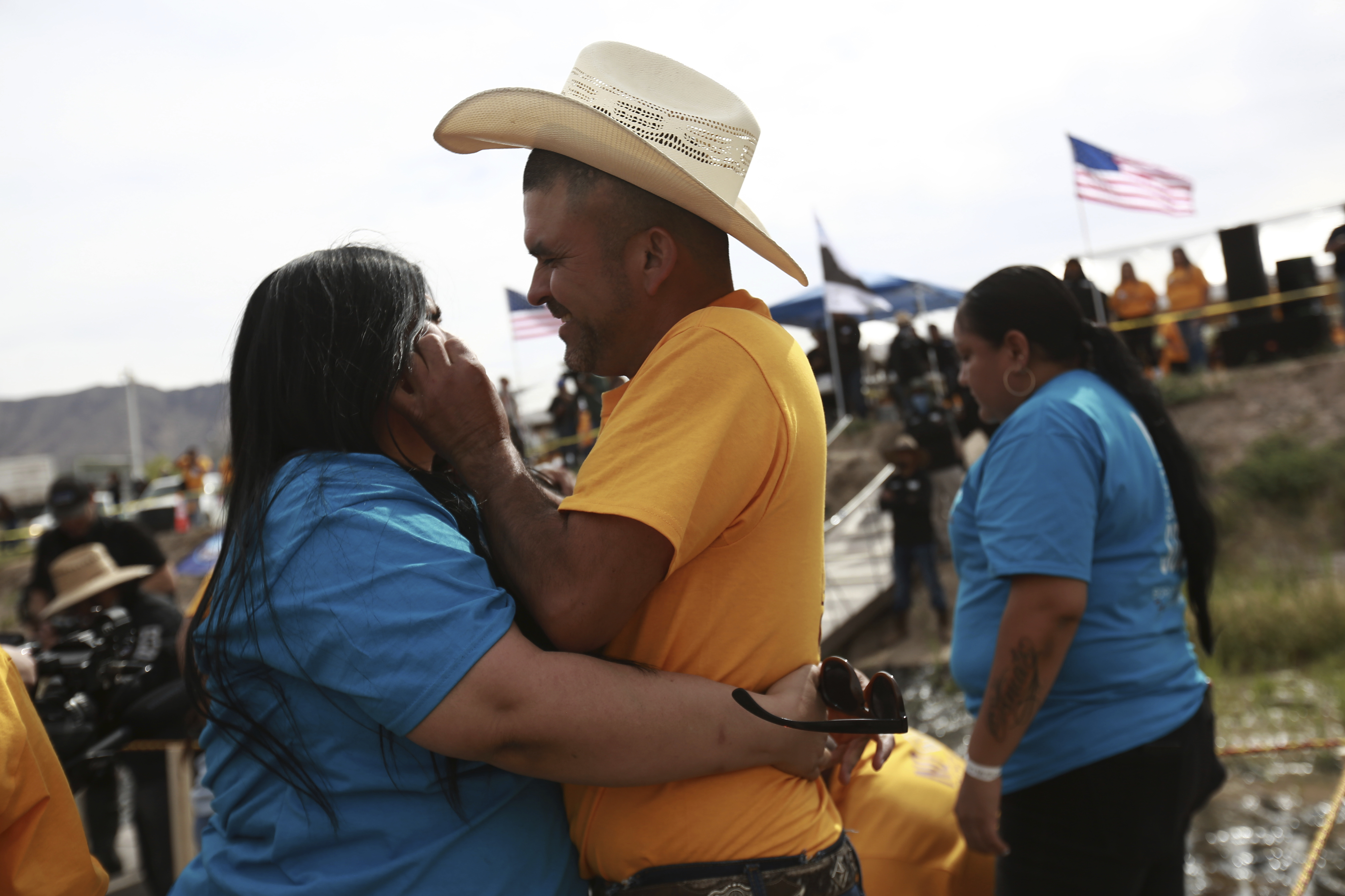 Personas que viven en Estados Unidos abrazan a parientes y amigos que radican en México durante el 10mo evento anual "Abrazos, no muros", en la franja del Río Bravo, en Ciudad Juárez, México, el sábado 6 de mayo de 2023. (AP Foto/Christian Chávez)