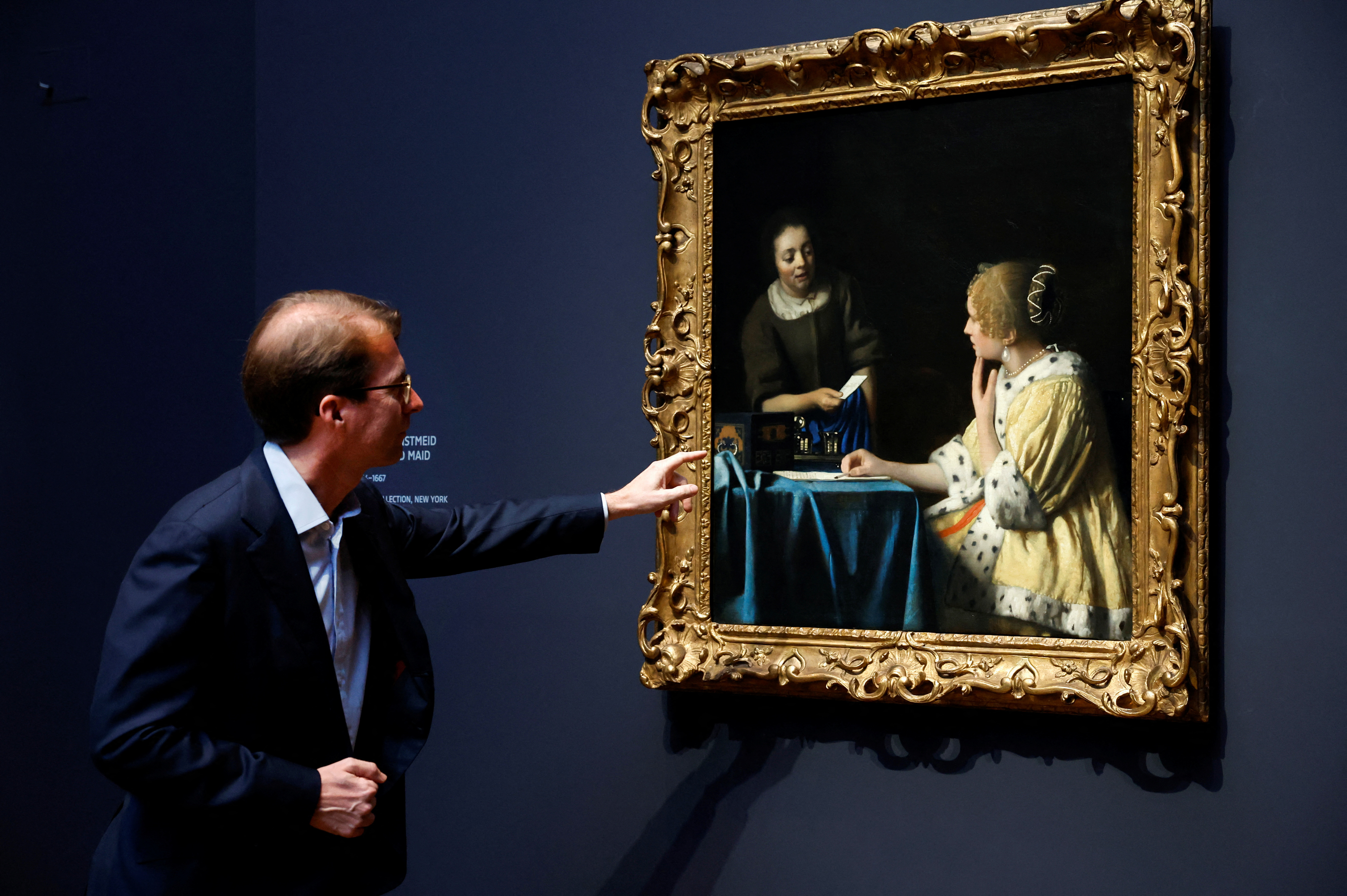 Taco Dibbits, director del Rijksmuseum de Amsterdam, muestra "Ama y criada" de Vermeer durante una exhibición (REUTERS/Piroschka van de Wouw)