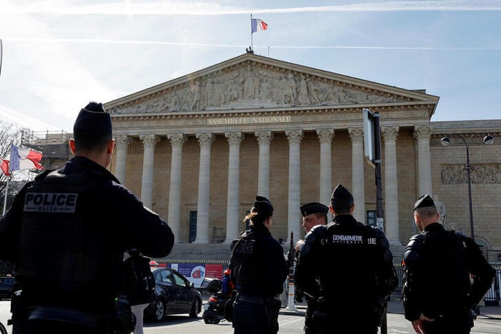 Policías y gendarmes franceses hacen guardia frente a la Asamblea Nacional antes de la votación sobre la reforma de las pensiones, en París (REUTERS/Pascal Rossignol)