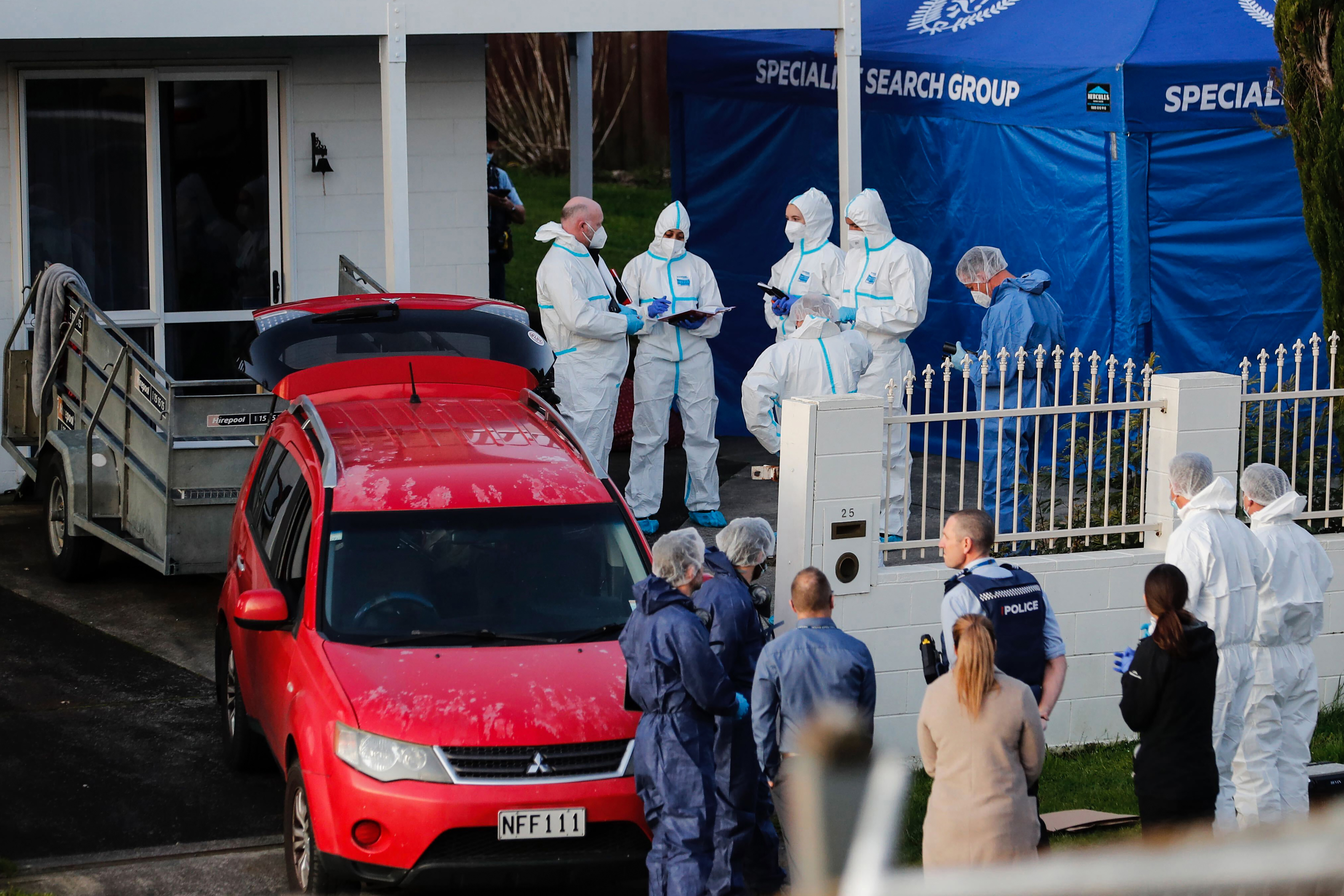 Ermittler der neuseeländischen Polizei arbeiten am Tatort, nachdem am 11. August 2022 in Auckland Leichen in Koffern gefunden wurden.  (AP über Dean Purcell/New Zealand Herald)