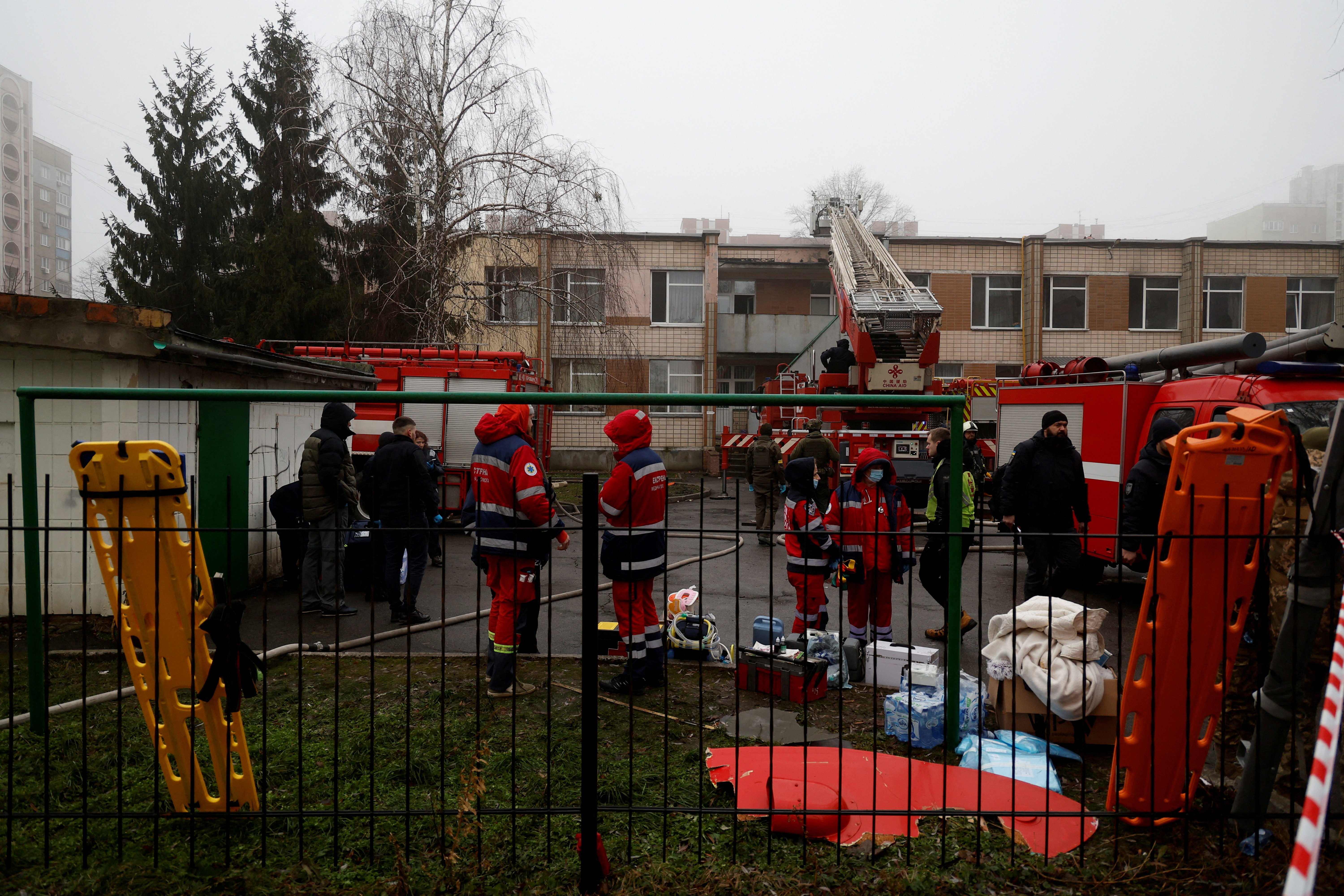 Doctors and emergency workers work at the site of a helicopter crash on civilian infrastructure buildings amid Russia's attack on Ukraine, in Brovary, outside Kyiv, Ukraine, on January 18, 2023.  REUTERS /Valentyn Ogirenko TPX Images