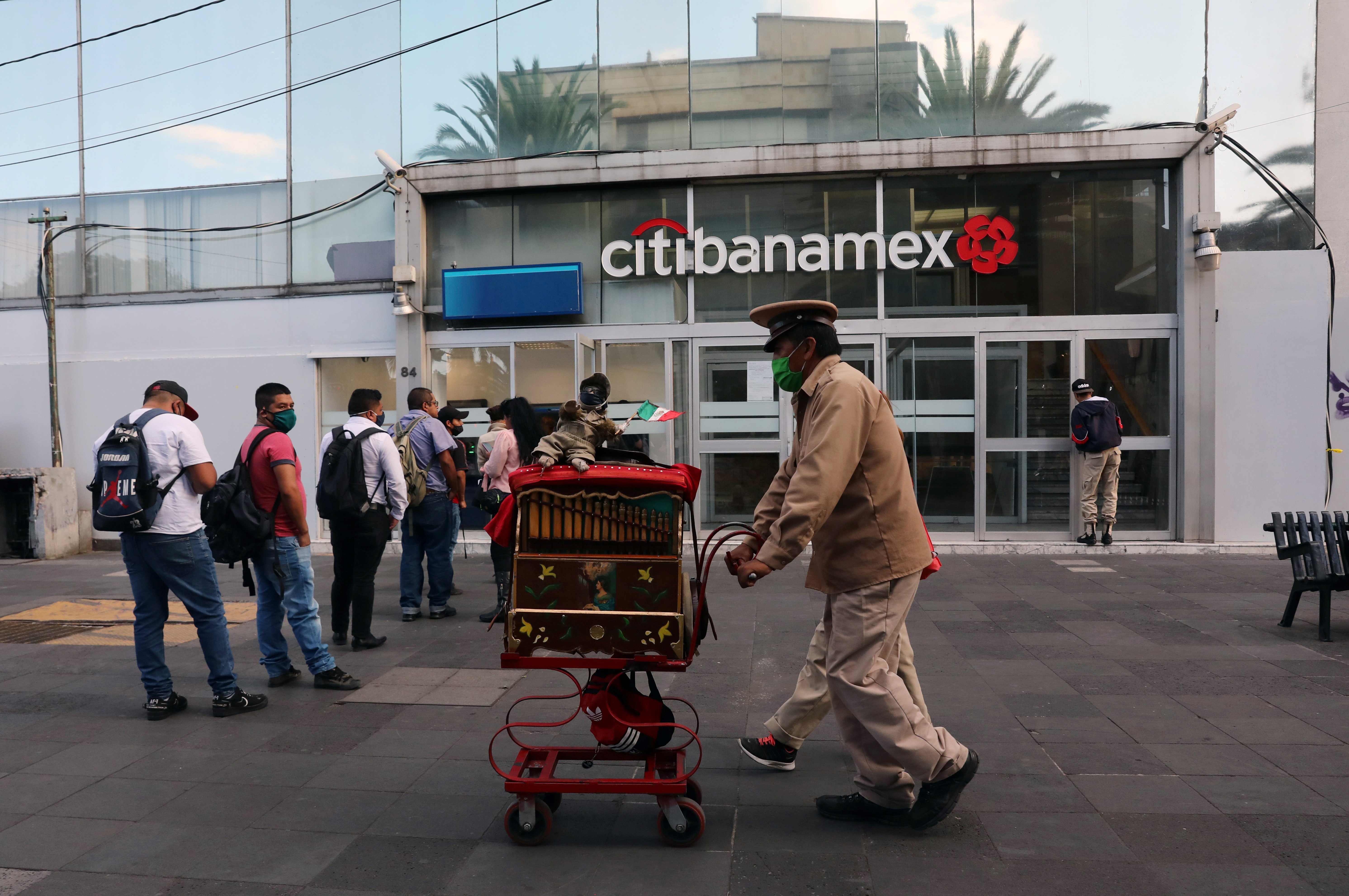 Un músico empuja un organillero a lo largo de una acera cuando el alcalde de la Ciudad de México dijo el viernes que la capital mexicana levantará las restricciones sobre el tráfico de automóviles y el transporte público. Ciudad de México, México, 12 de junio de 2020. Foto: Reuters.
