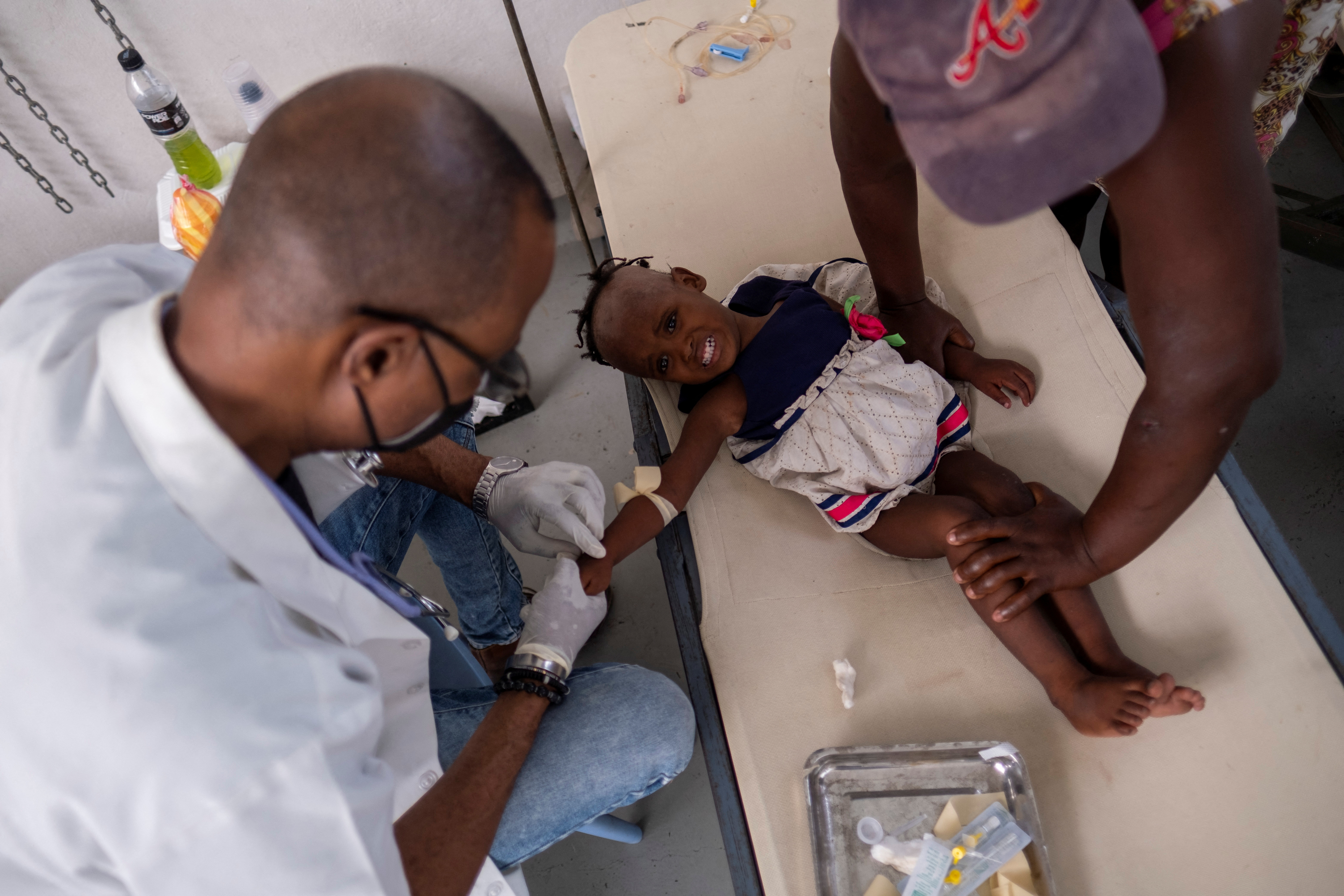 A doctor treats 3-year-old Camare St Ville at the UNICEF-supported Gheskio Center Hospital in Port-au-Prince, Haiti, on October 14, 2022.  REUTERS/Ricardo Arduengo/File