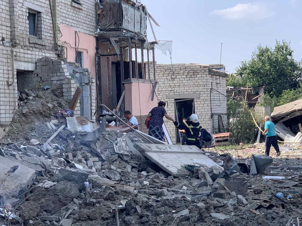 Un rescatista ayuda a una mujer a ser evacuada de un edificio residencial bombardeado en Voznesensk, región de Mykolaiv, Ucrania, el 20 de agosto de 2022 (REUTERS)