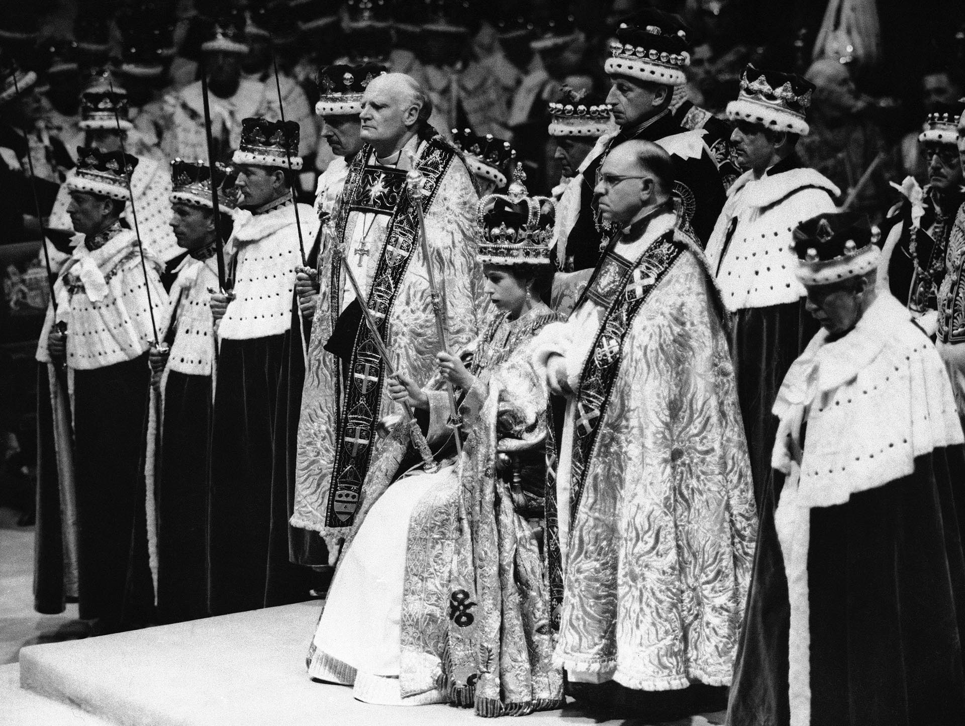La reina Isabel II de Gran Bretaña es coronada monarca de Gran Bretaña sosteniendo el cetro real, sentada en el trono, vistiendo la corona de San Eduardo, en la Abadía de Westminster, en Londres, el 2 de junio de 1953. (AP Foto, Archivo) 