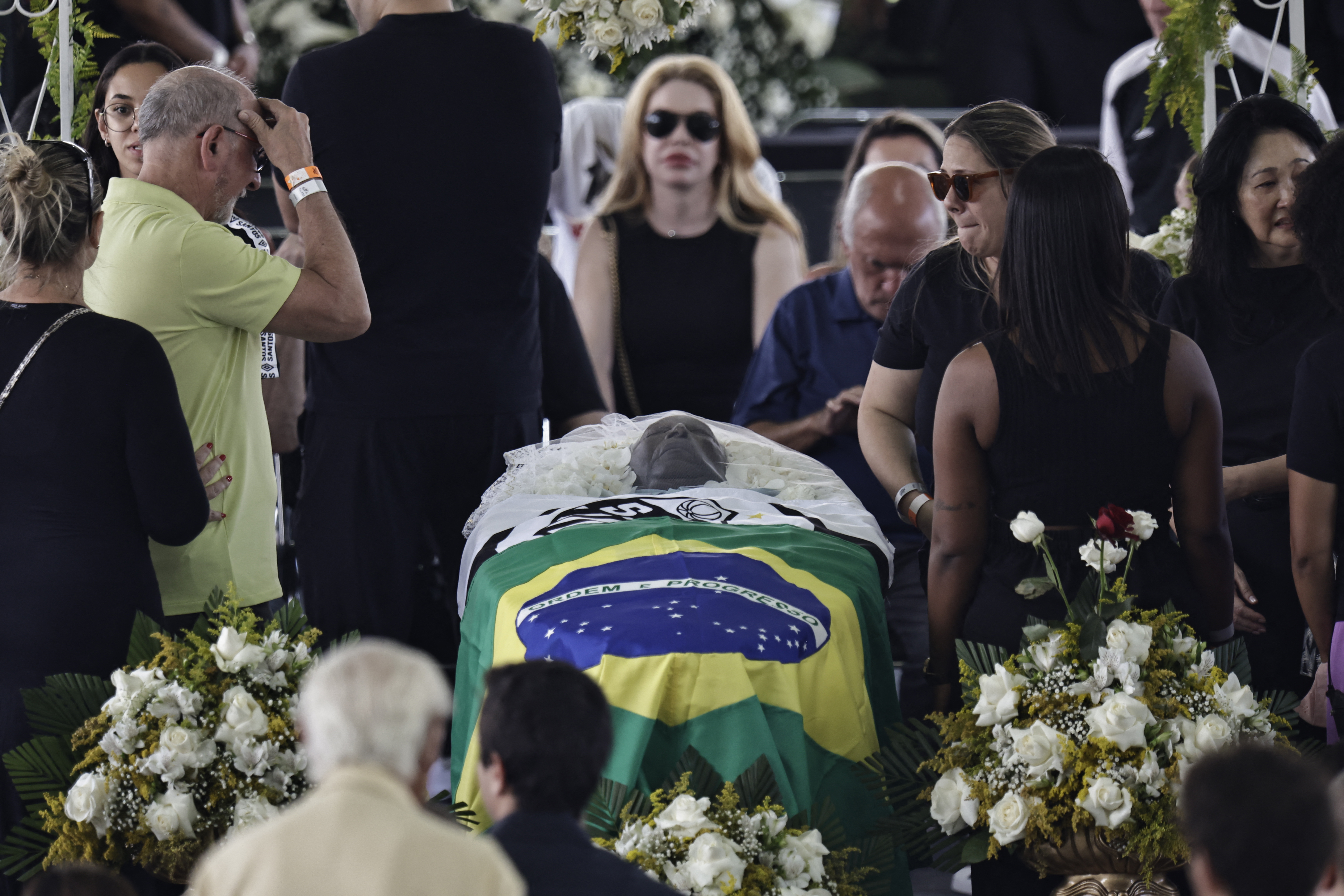 Soccer Football - Death of Brazilian soccer legend Pele - Vila Belmiro Stadium, Santos, Brazil - January 2, 2023 SENSITIVE MATERIAL. THIS IMAGE MAY OFFEND OR DISTURB Brazilian soccer legend Pele is seen in his casket, on the pitch of his former club Santos' Vila Belmiro stadium as mourners look on while he lays in state REUTERS/Ueslei Marcelino
