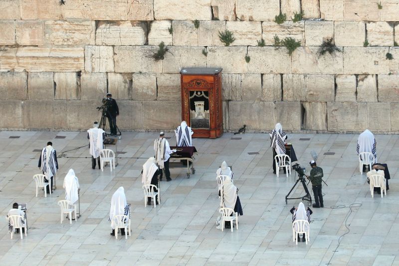 Un pequeño número de fieles judíos rezan durante la bendición sacerdotal, una oración tradicional que suele atraer a miles de adoradores en el Muro de las Lamentaciones en el día de la Pascua, en medio del brote de la enfermedad coronavirus (COVID-19) (REUTERS/Ronen Zvulun)