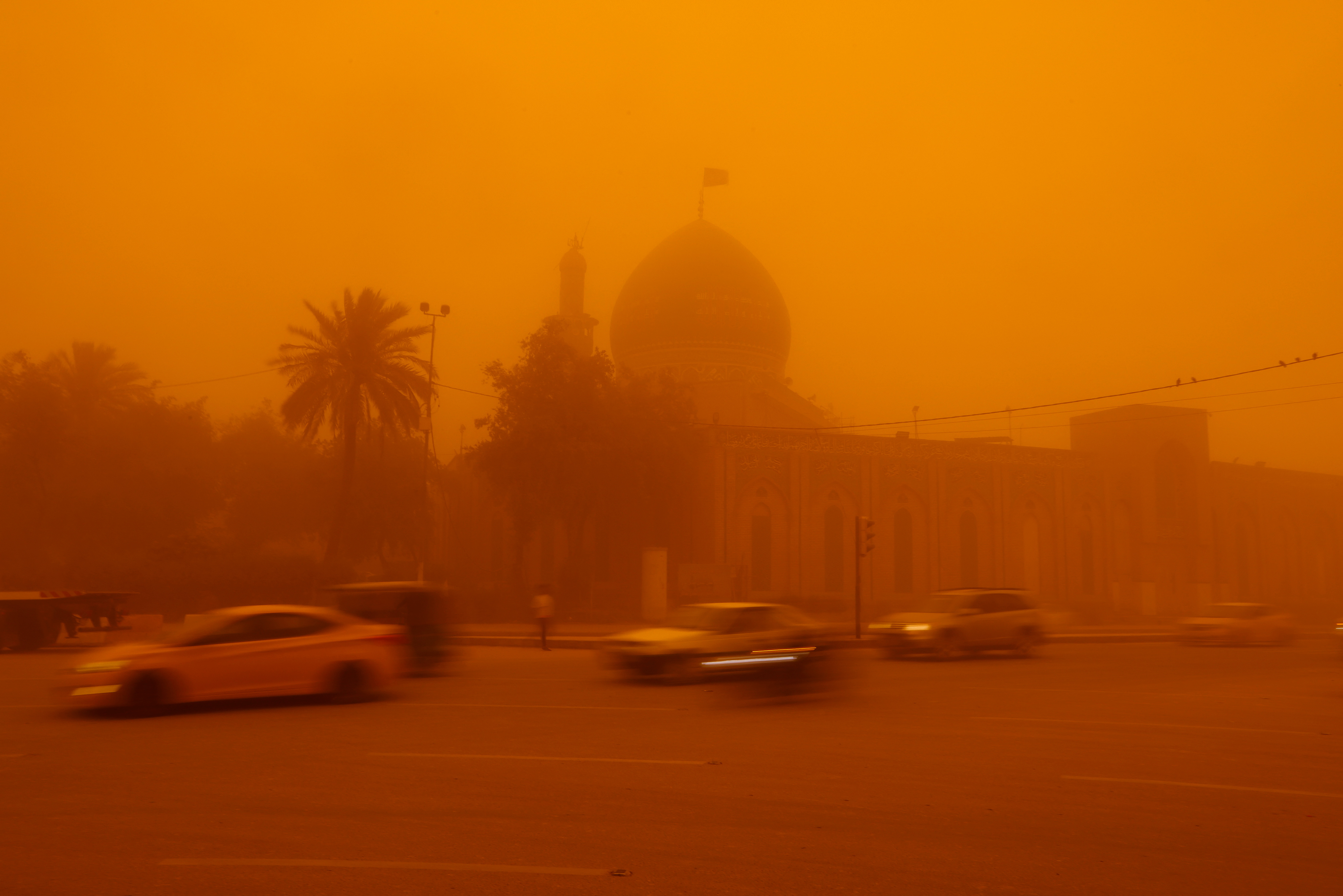 Autos pasan por una mezquita en medio de una tormenta de arena en Bagdad, Irak, el 16 de mayo de 2022. REUTERS/Ahmed Saad
