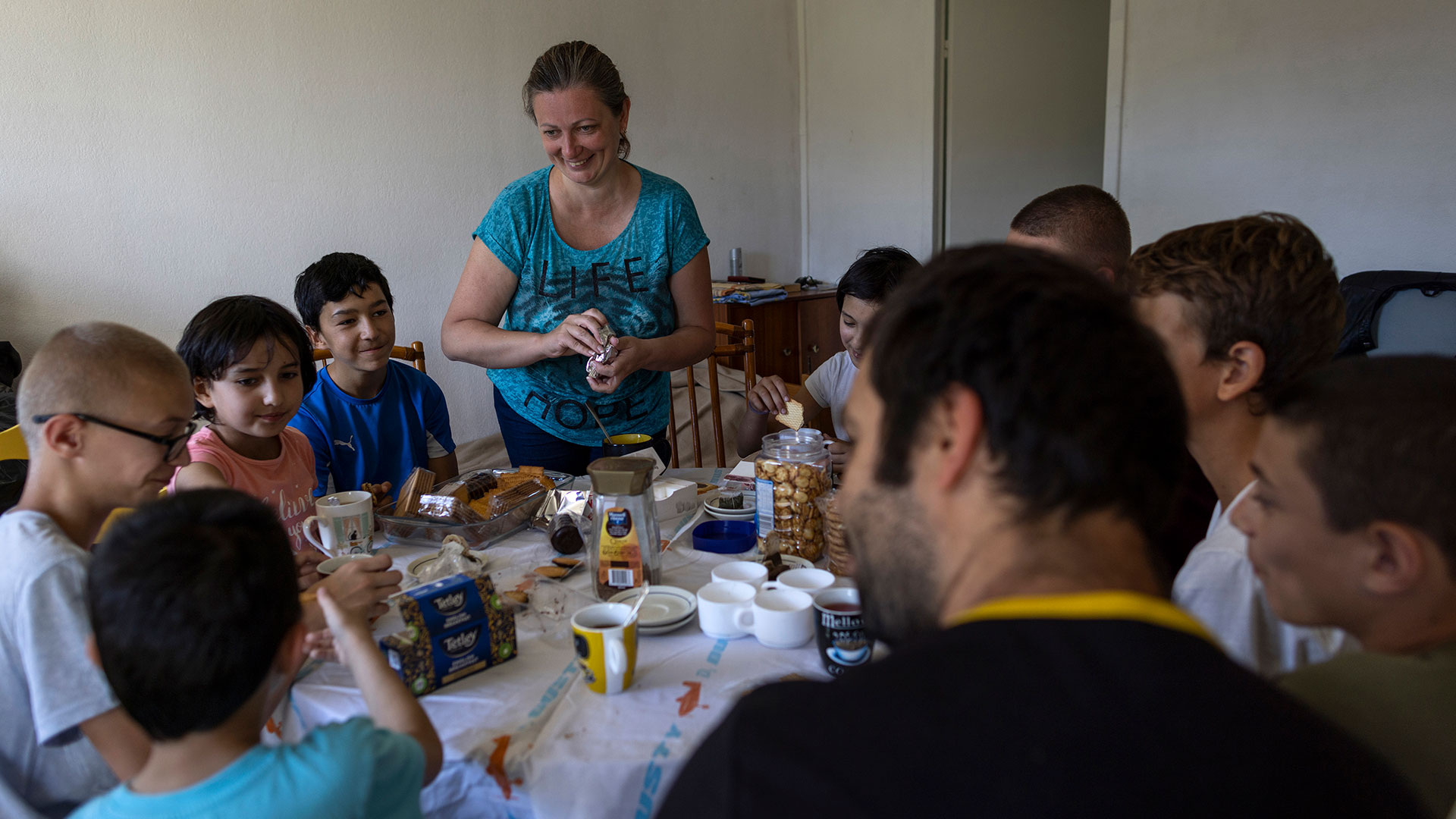Olga Lopatkina, en el centro, sirve un bocadillo a su familia, en Loue, al oeste de Francia (AP Photo/Jeremias Gonzalez)