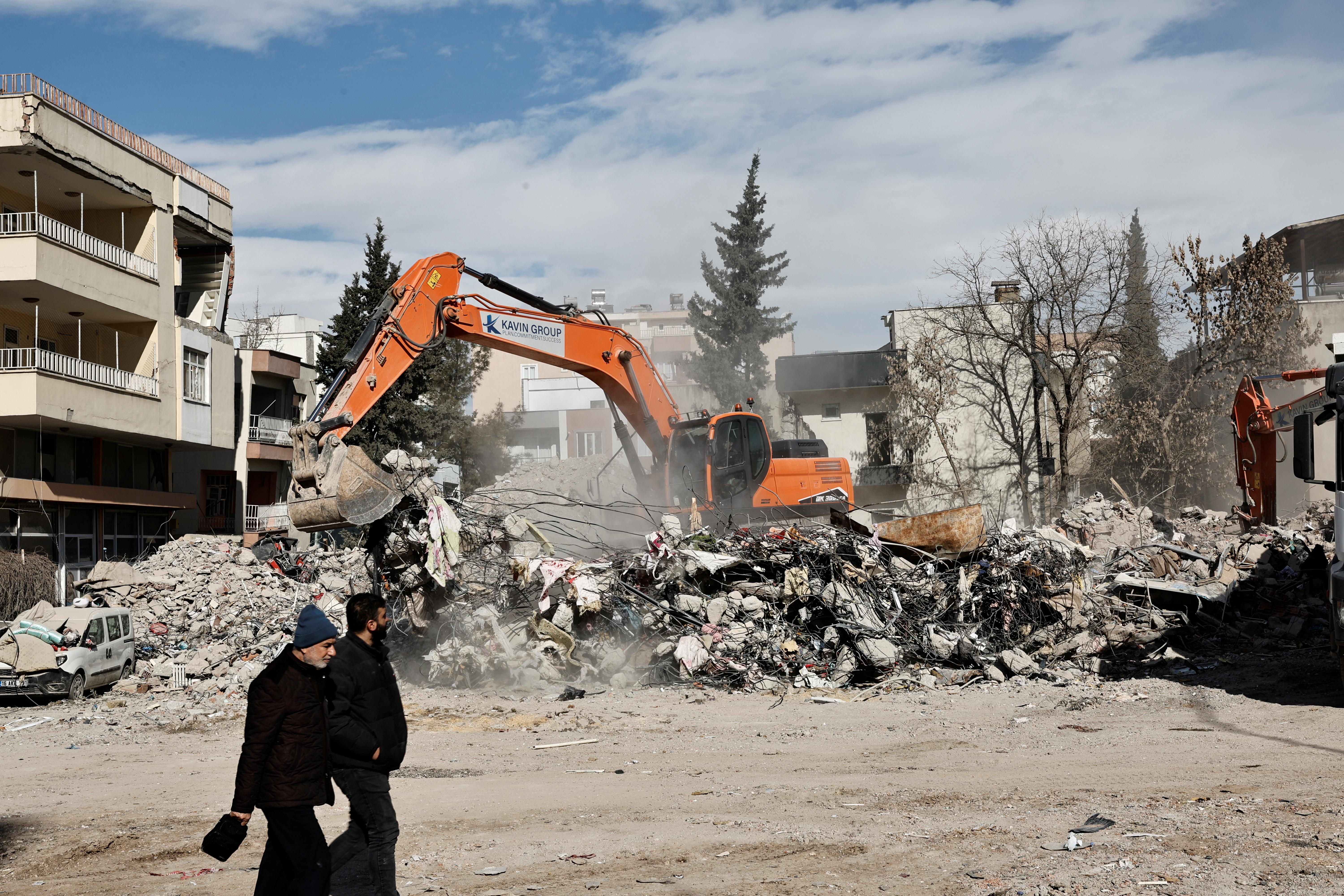 Unos hombres pasan junto a un edificio derrumbado, tras el mortífero terremoto, en Adiyaman,Turquía 15 de febrero de 2023. REUTERS/Thaier Al-Sudani