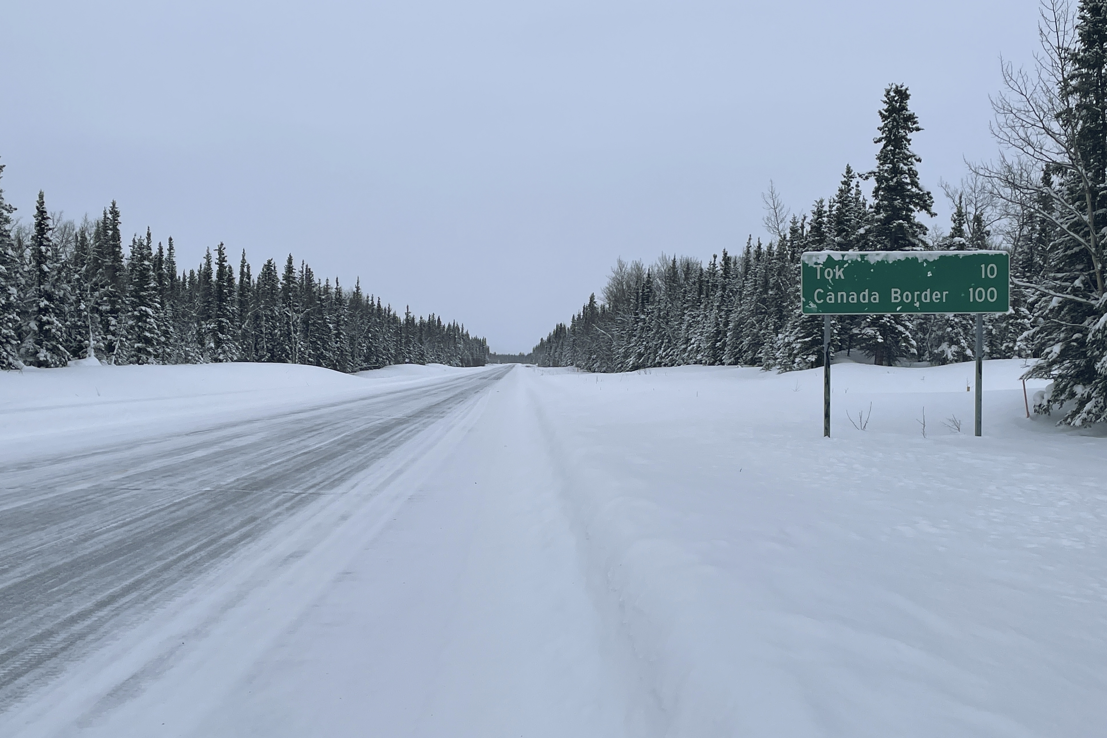 Un letrero muestra la distancia a la localidad de Tok, Alaska, y a la frontera con Canadá el 1 de febrero de 2023, en Glennallen, Alaska. (AP Foto/Mark Thiessen)