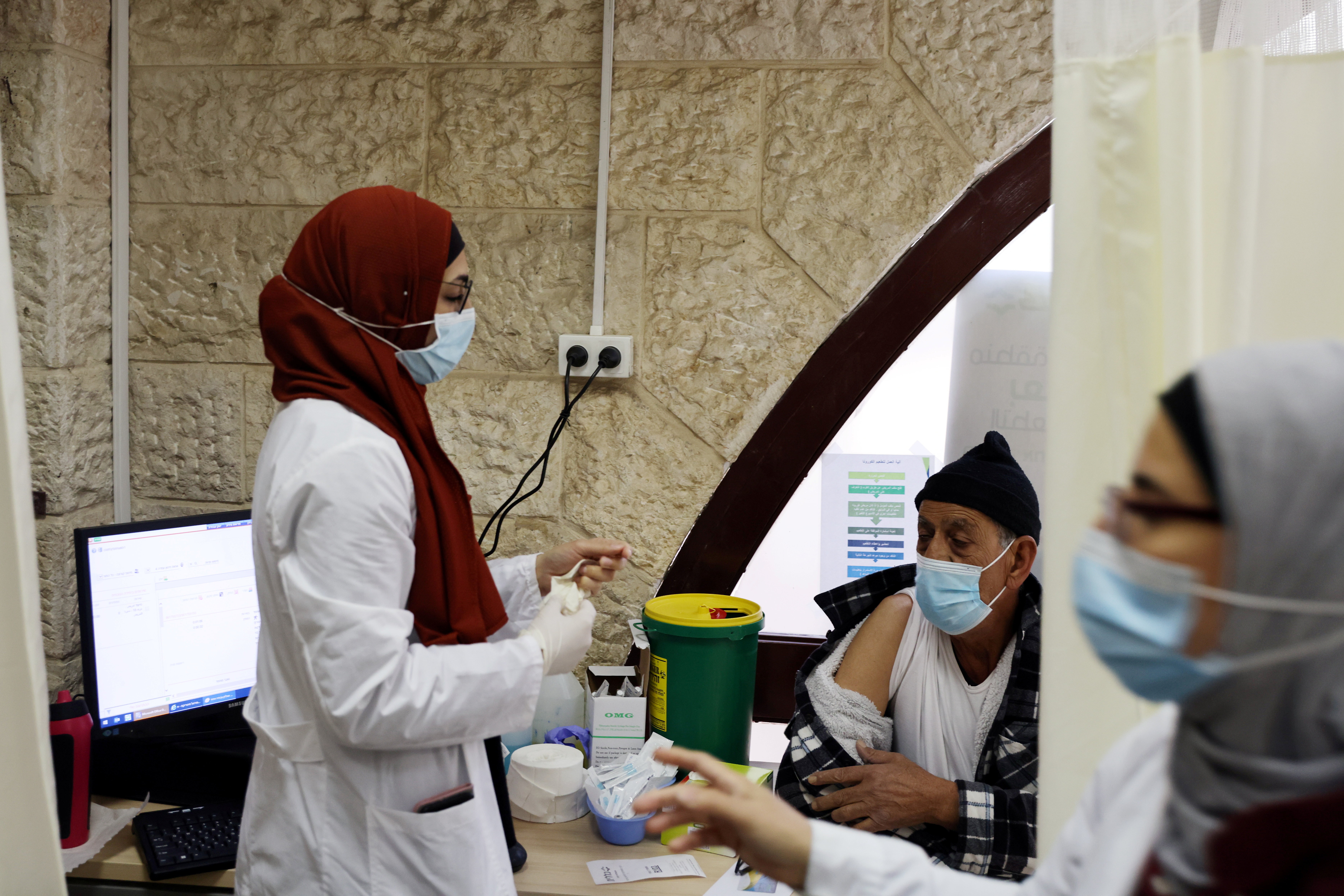 Un trabajador médico se prepara para vacunar a un hombre contra la enfermedad del coronavirus mientras Israel continúa su campaña nacional de vacunación (Reuters)