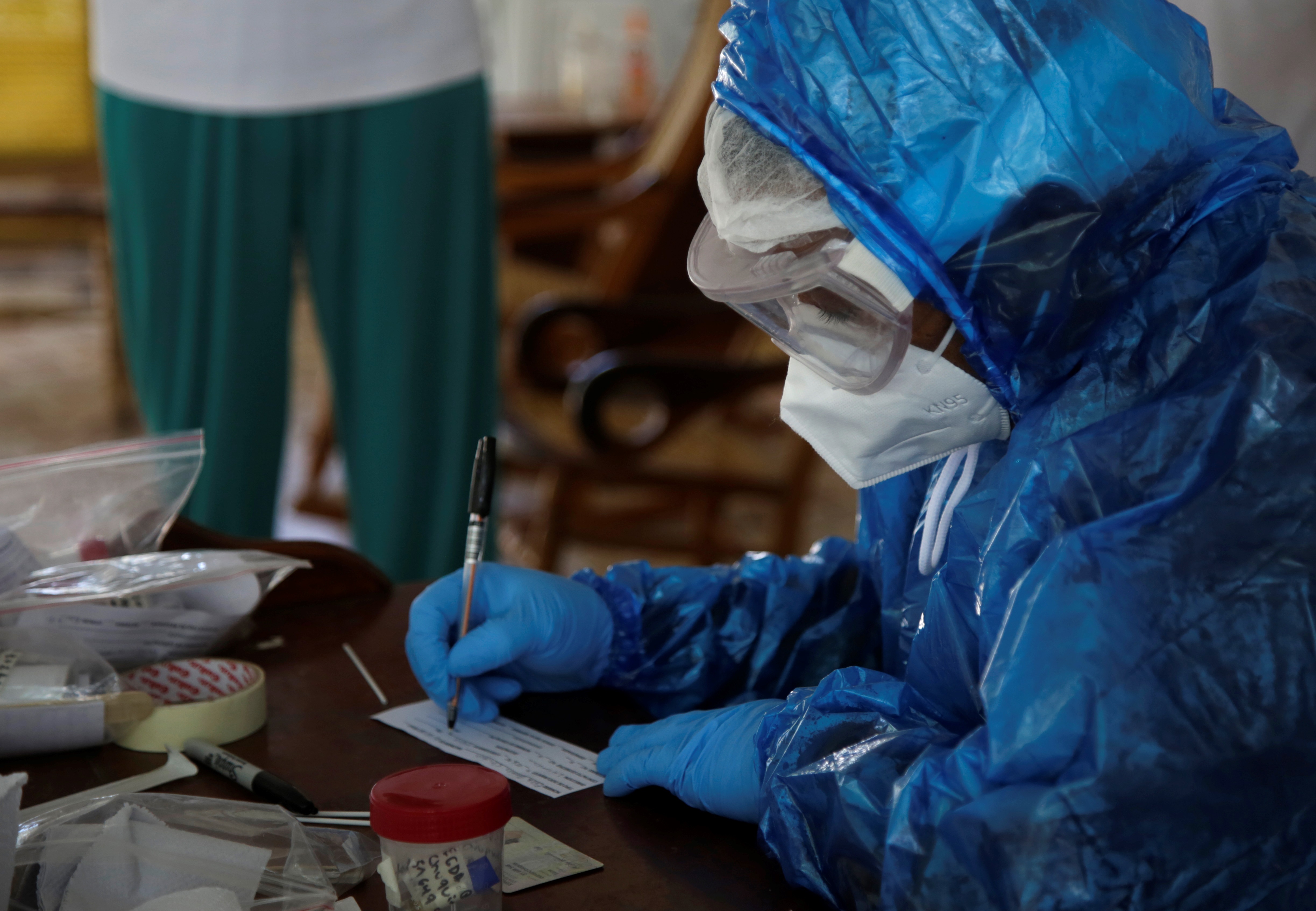Un profesional de la salud mientras llena un formulario de prueba PCR para covid-19 durante una jornada de testeo Cartagena (Colombia). EFE/Ricardo Maldonado Rozo
