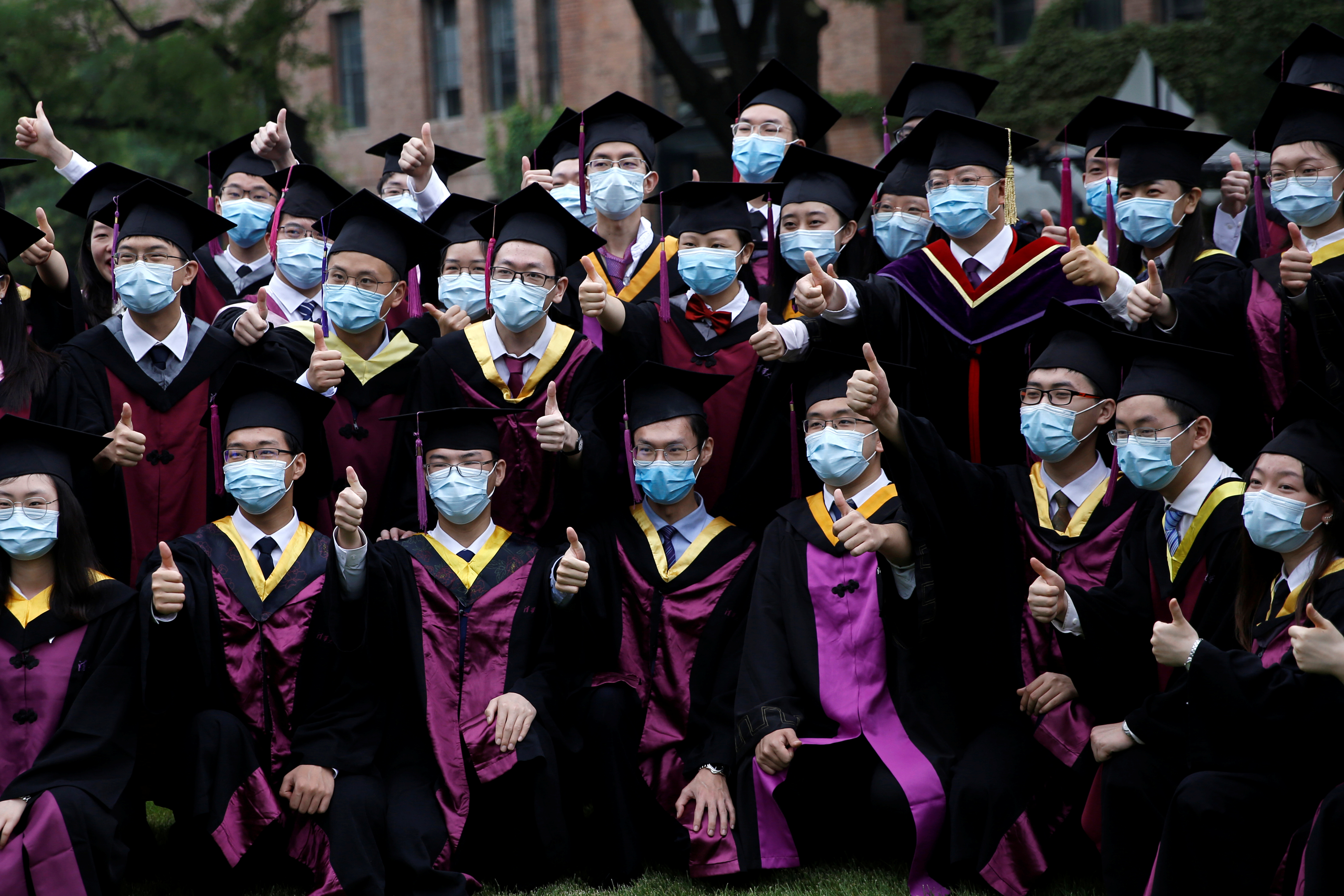 Estudiantes universitarios posan para fotos mientras asisten a una ceremonia de graduación en la Universidad de Tsinghua, el 23 de junio de 2020. (REUTERS/Tingshu Wang)