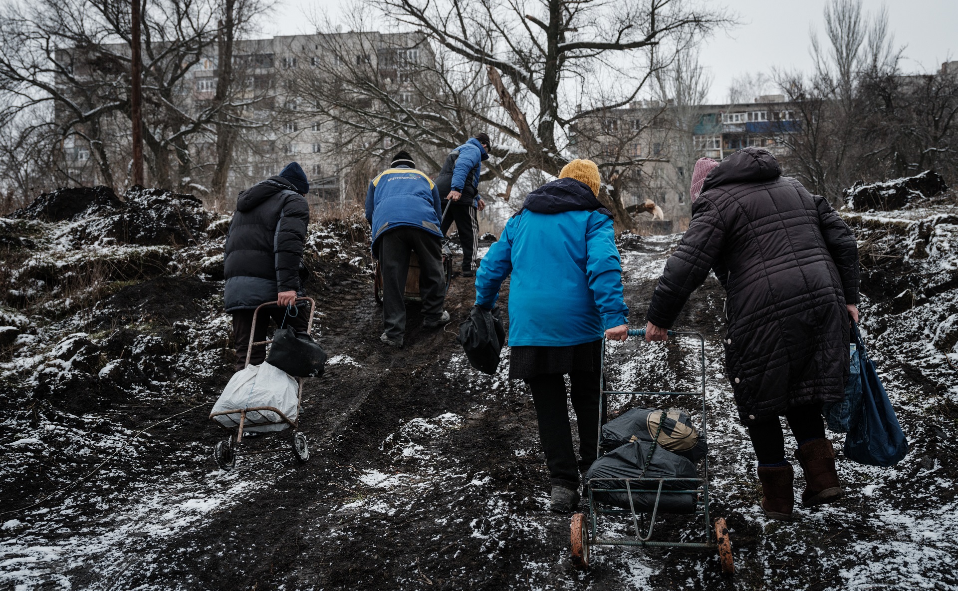 Adultos mayores regresas a sus hogares tras recibir alimentos en un centro humanitario en Bajmut, en medio de bombardeos rusos (AFP)