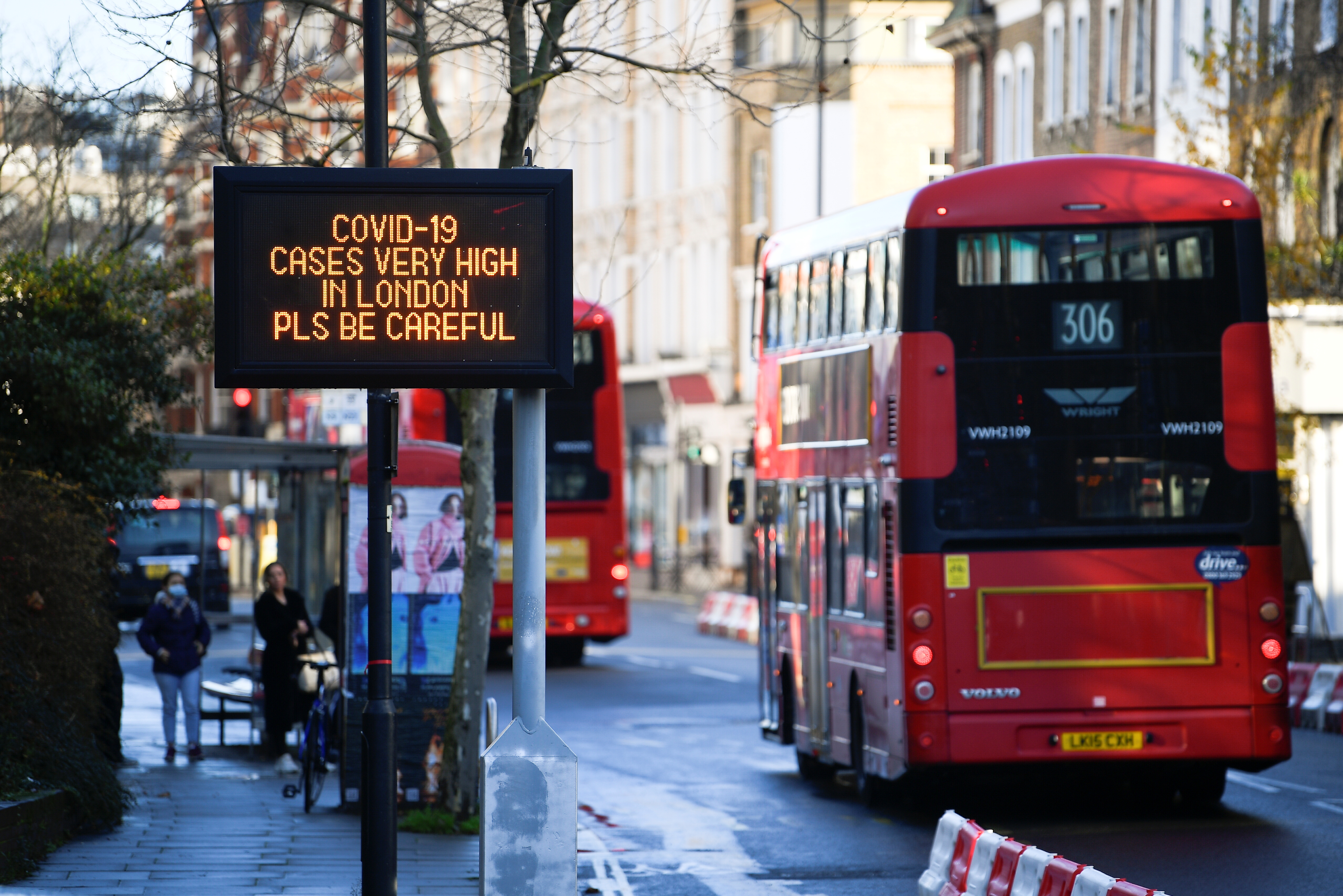Los autobuses pasan un cartel con un mensaje de información sobre la salud pública, en medio de la propagación de la enfermedad del coronavirus (COVID-19), a medida que entran en vigor nuevas restricciones, en Londres, Gran Bretaña, el 20 de diciembre de 2020. REUTERS/Toby Melville