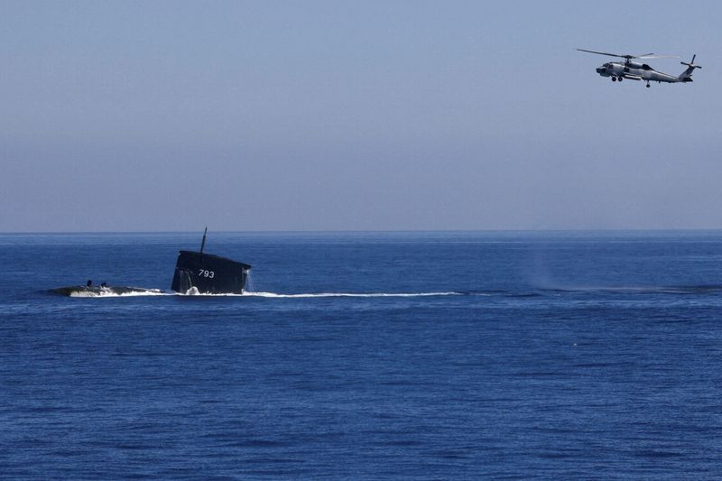 Un helicóptero S70C puede verse volando alrededor del submarino SS793 como parte de los principales ejercicios anuales "Han Kuang" de Taiwán, en Yilan, Taiwán. 26 de julio de 2022. (REUTERS/Ann Wang)