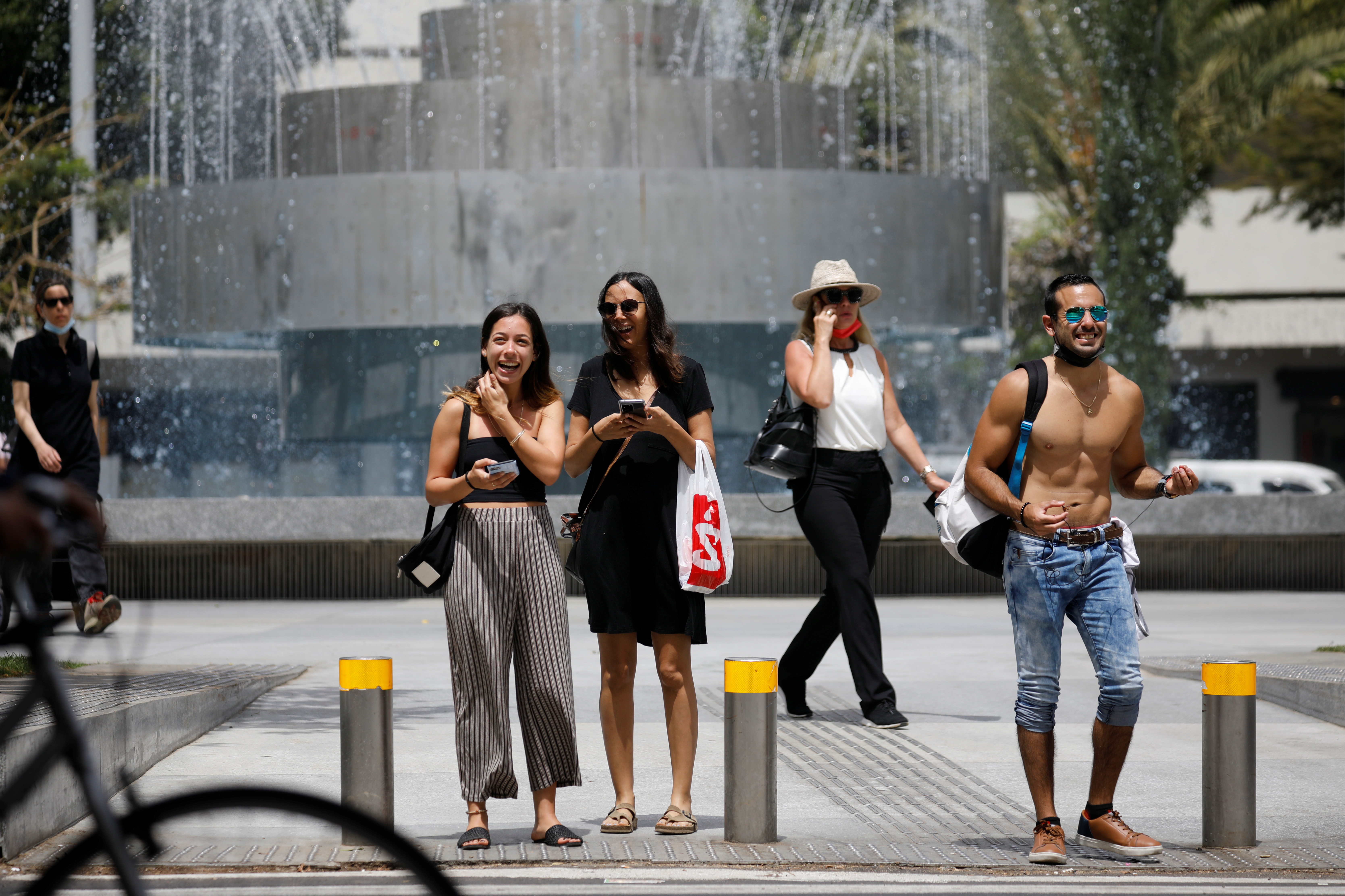 Los peatones esperan para cruzar una calle mientras Israel rescinde el uso obligatorio de mascarillas al aire libre en la última vuelta a la relativa normalidad (Reuters)