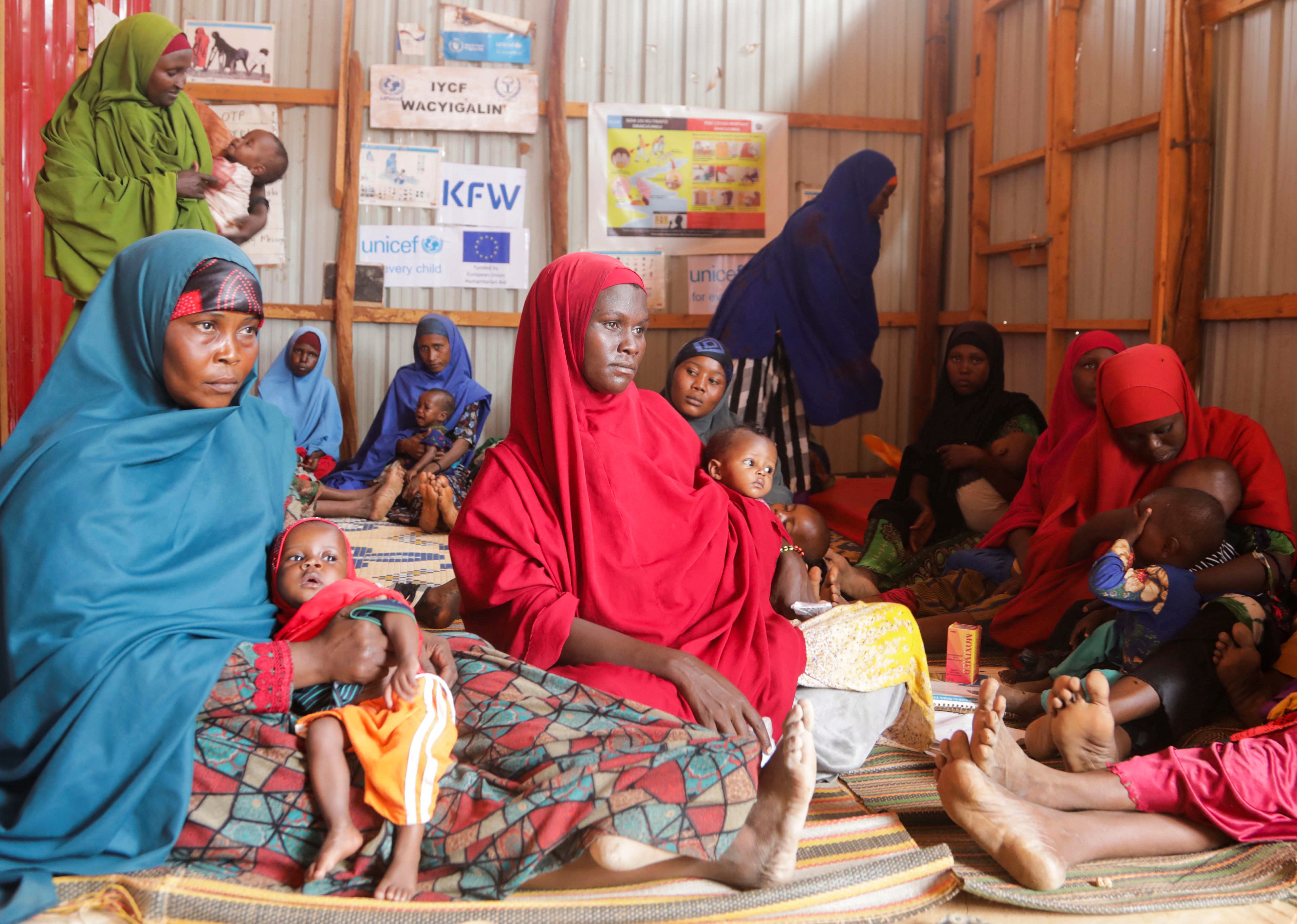 Mujeres somalíes desplazadas internamente llevan a sus hijos mientras esperan a que se les realice un examen de desnutrición en el hospital de Dollow, en la región de Gedo, Somalia. Las últimas semanas resultaron dramáticas para gran parte de la población somalí (Reuters)