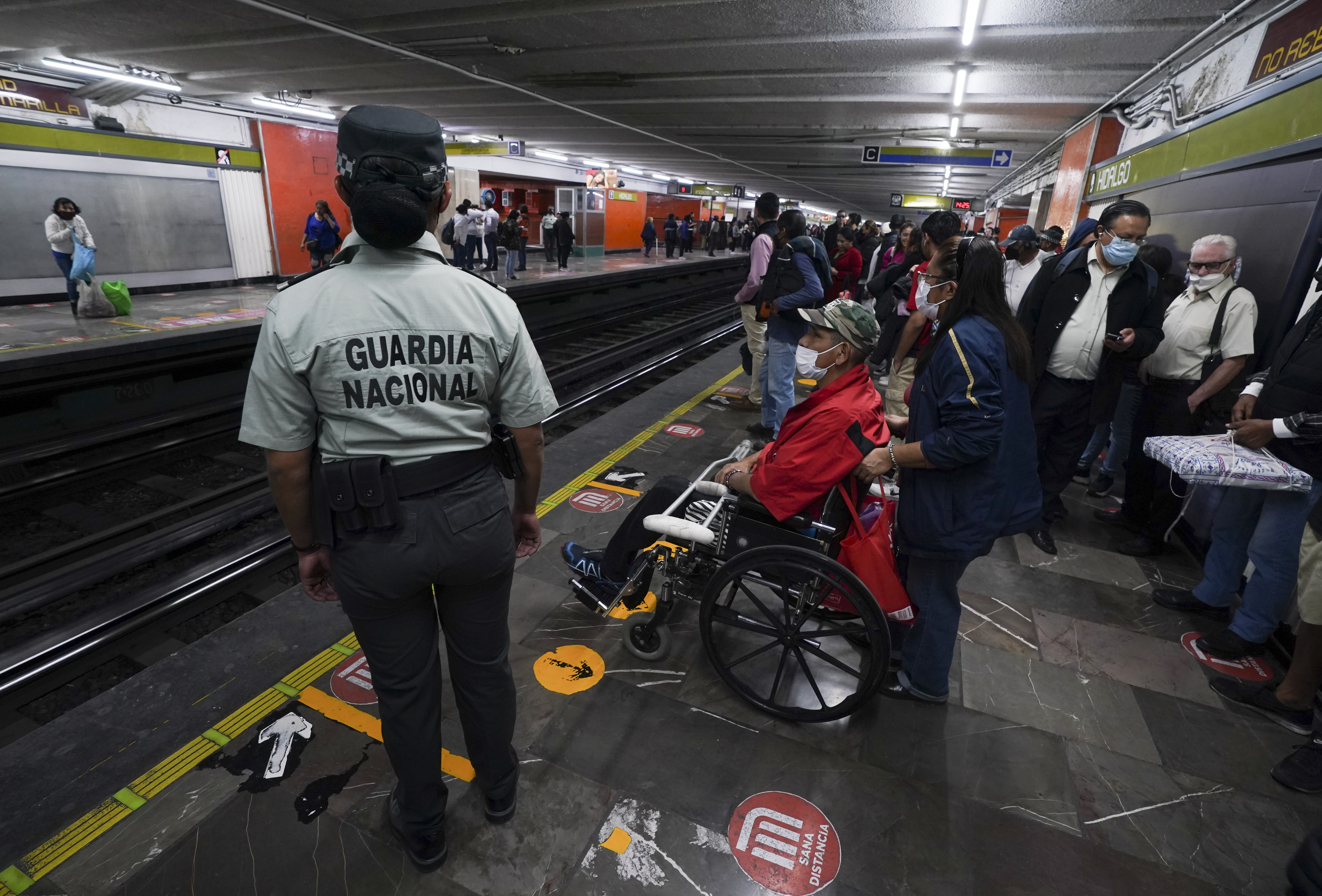 A National Guard agent watches a subway platform in Mexico City, on Thursday, January 12, 2023, after the authorities ordered to reinforce surveillance in that transport system before what they consider a series of "atypical and deliberate incidents".  (AP Photo/Fernando Llano)