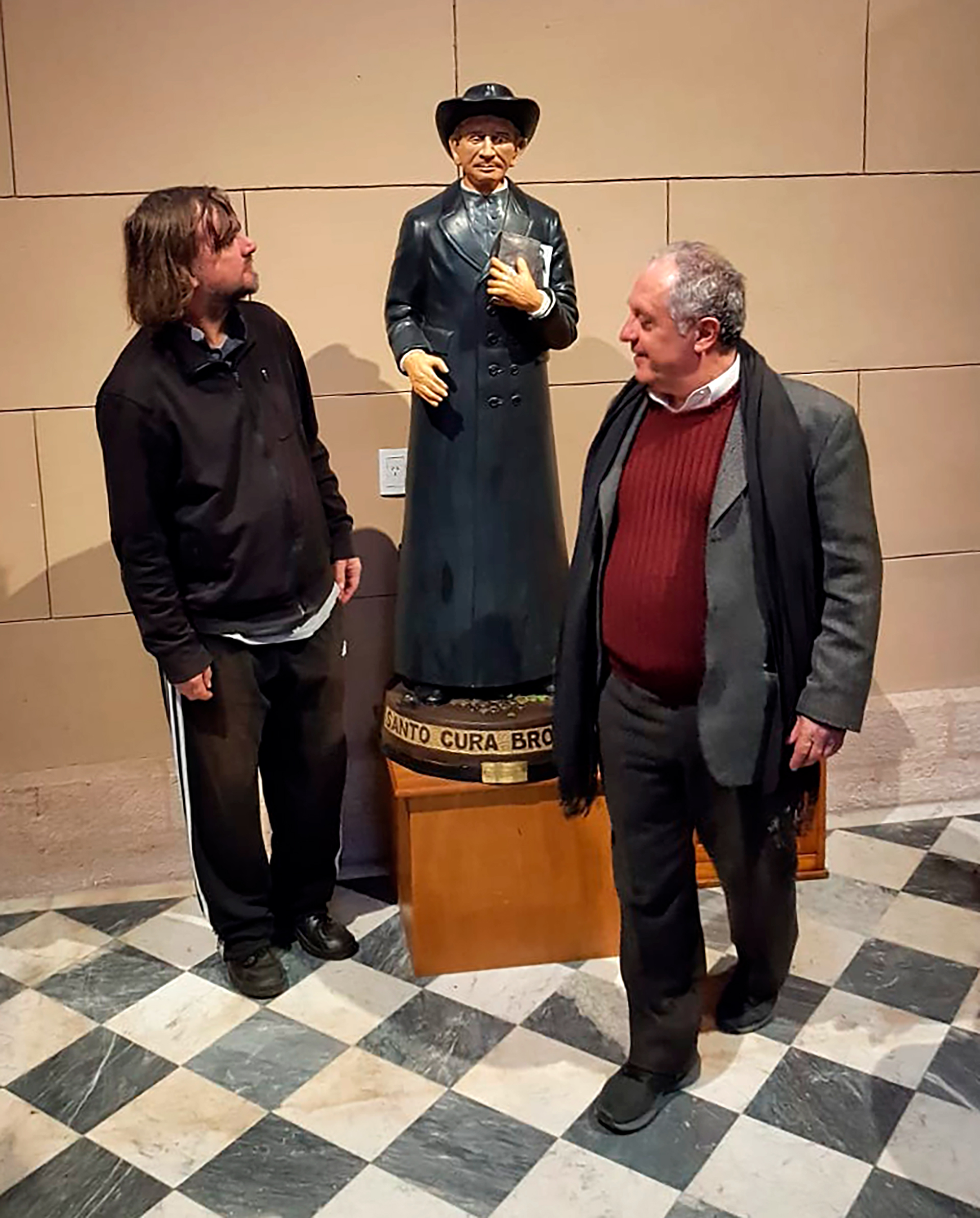 Pepe Di Paola y Alver Metalli junto a una imagen del cura Brochero, hoy santo
