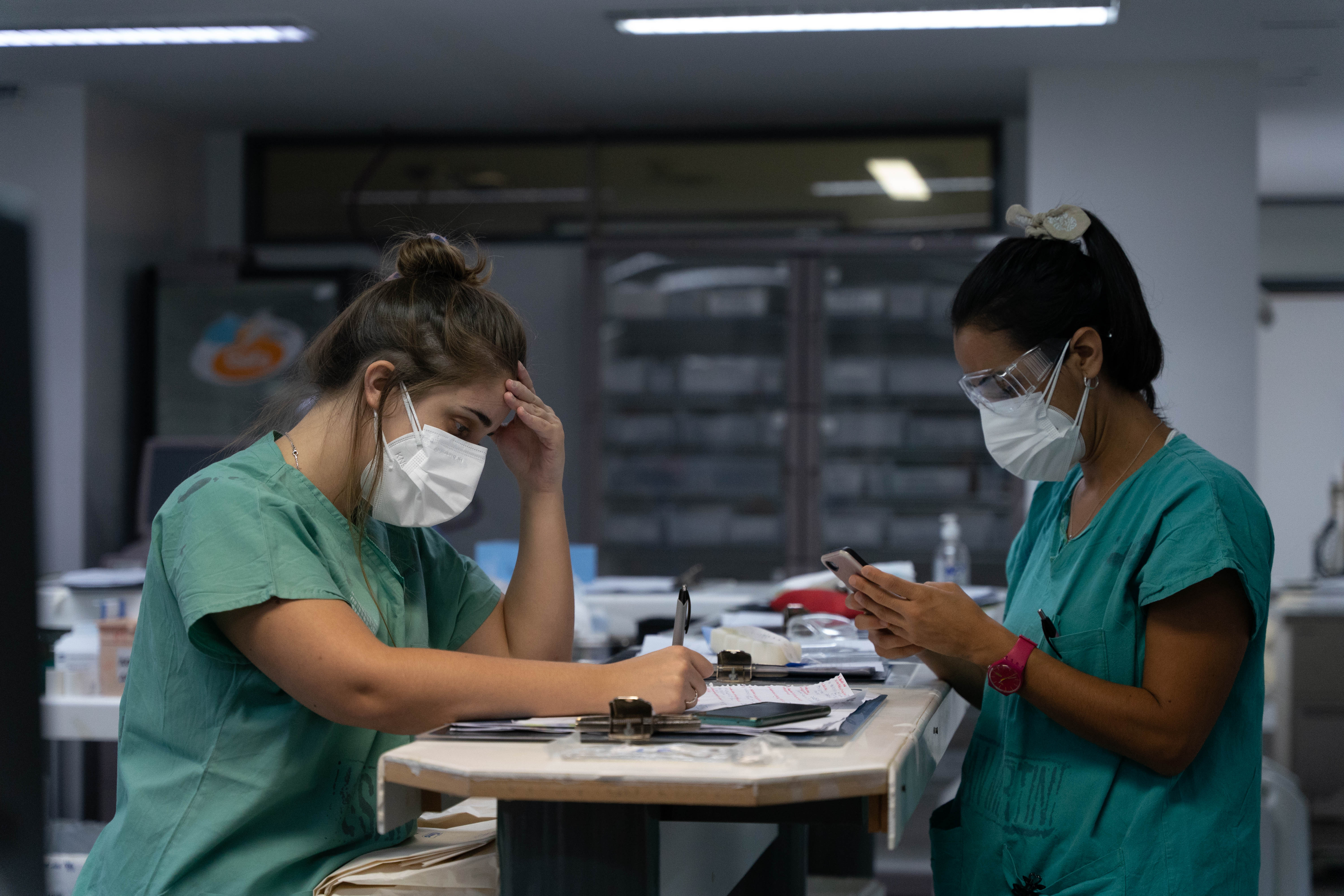 Dos enfermeras tomando registro del estado de sus pacientes. El agotamiento, otra postal repetida en las UTI. (Foto: Franco Fafasuli)