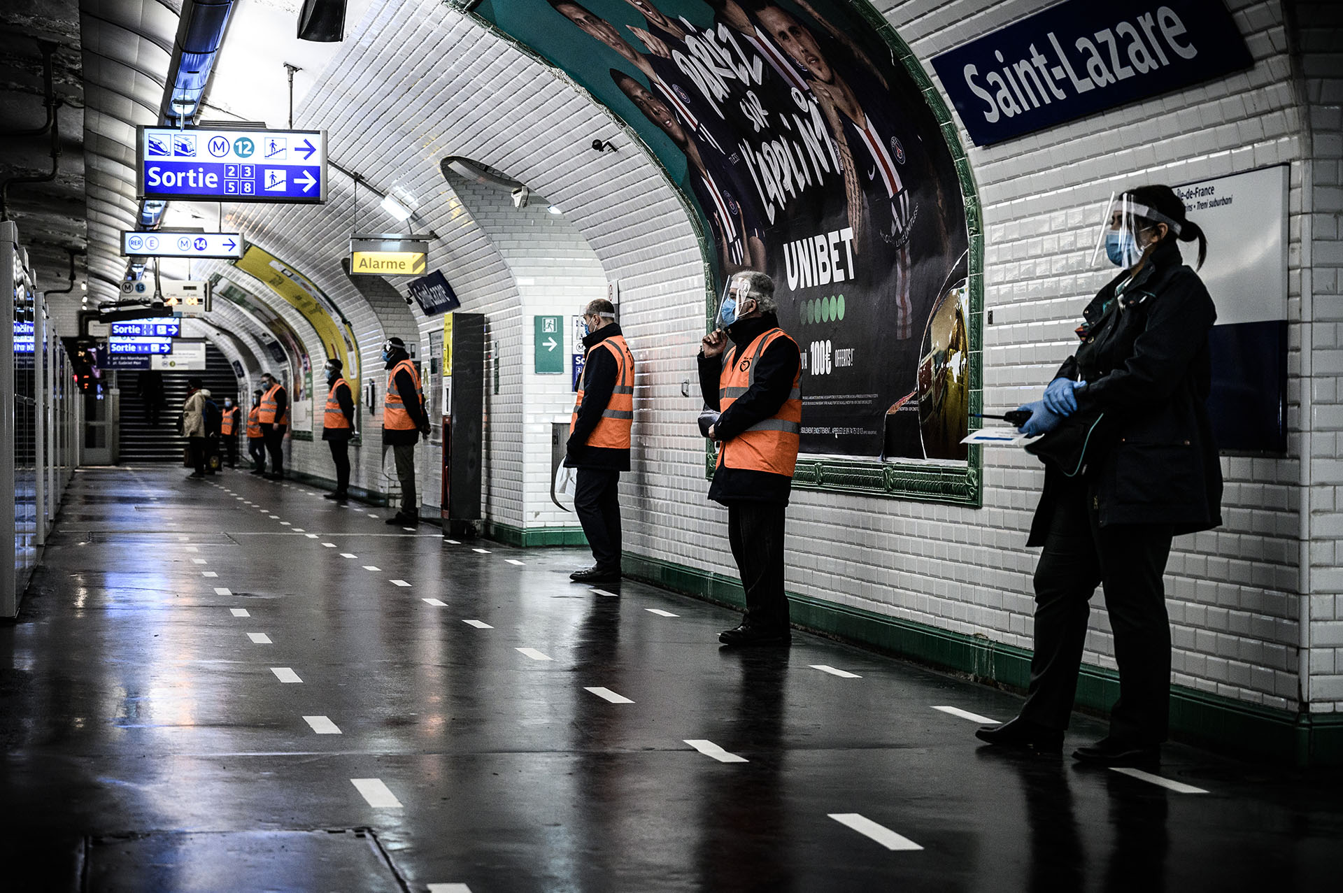 Empleados de la Autoridad Parisina del Transporte controlan que se mantenga la distancia social en la estación Saint-Lazare del metro de la capital francesa.