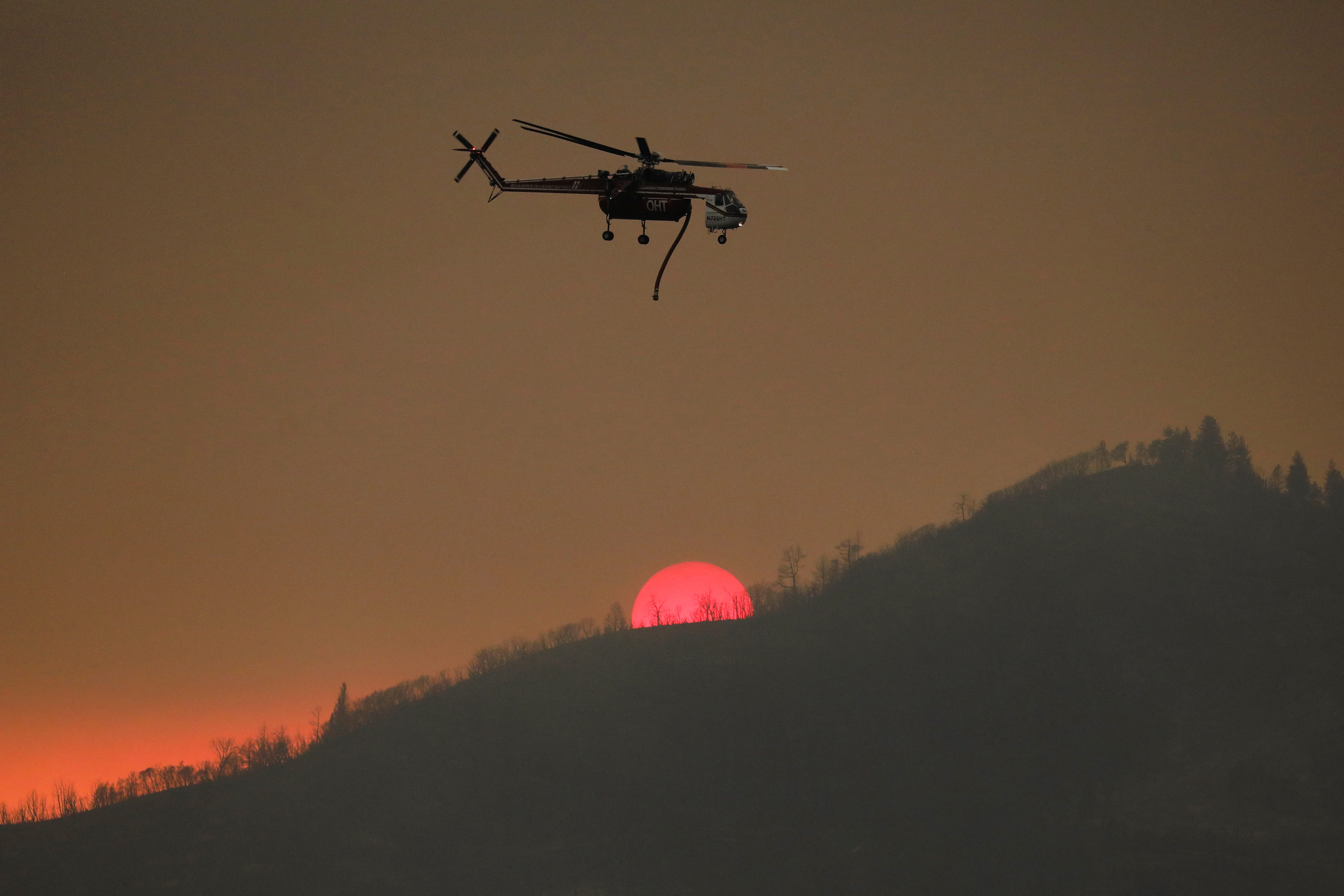 Un helicóptero del servicio contra incendios de California sobrevuela la zona del siniestro en Oak cerca de Darrah en el condado Mariposa de California (REUTERS/David Swanson)