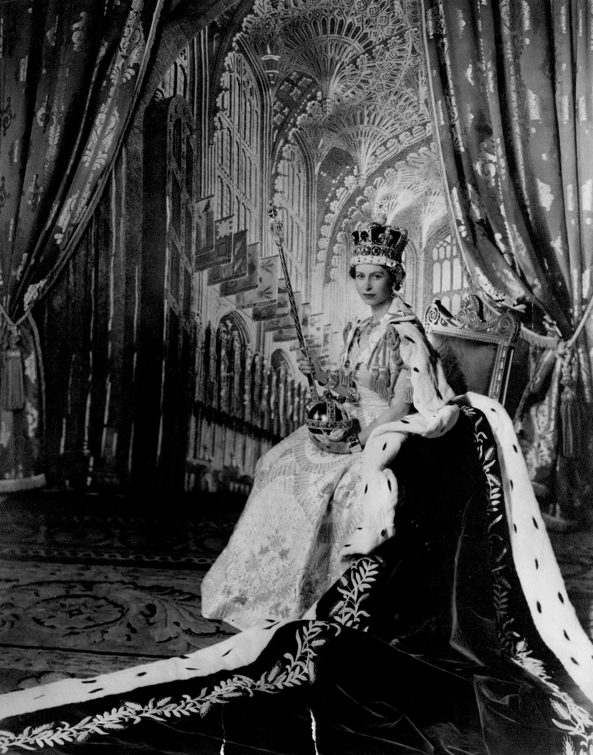 La reina Isabel II lució la corona imperial de San Eduardo, que data de 1661, es de oro macizo, pesa dos kilos y mide 31,5 centímetros. Está adornada con zafiros turmalinas, topacios, amatistas y perlas. La monarca posa con el cetro con la cruz y el orbe, una esfera de oro con gemas, que simboliza su rol de defensora de la fe (Zuma Press/The Grosby Group)