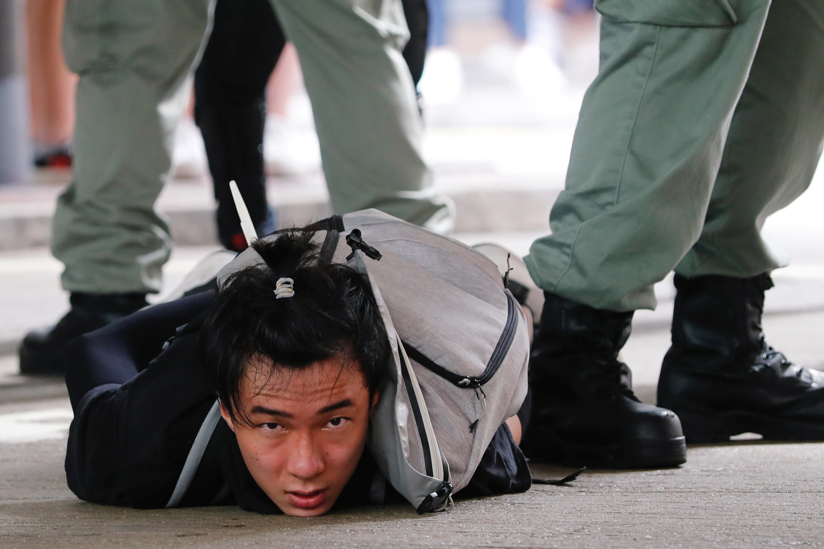Un manifestante en el suelo, detenido por la policía de Hong Kong
