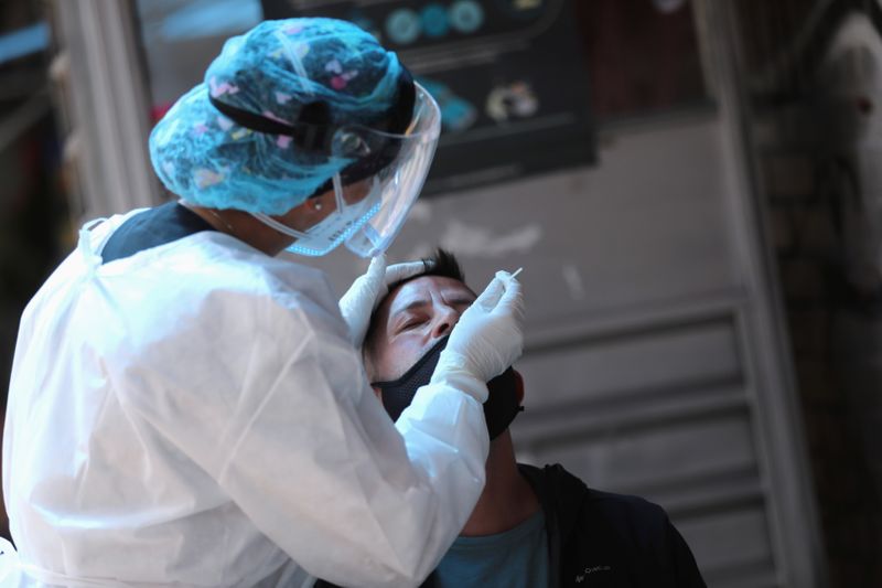 IMAGEN DE ARCHIVO. Una integrante de un equipo médico toma una muestra de un hisopo a un hombre en medio del brote de coronavirus, en Bogotá, Colombia. Diciembre 29, 2020. REUTERS/Luisa Gonzalez