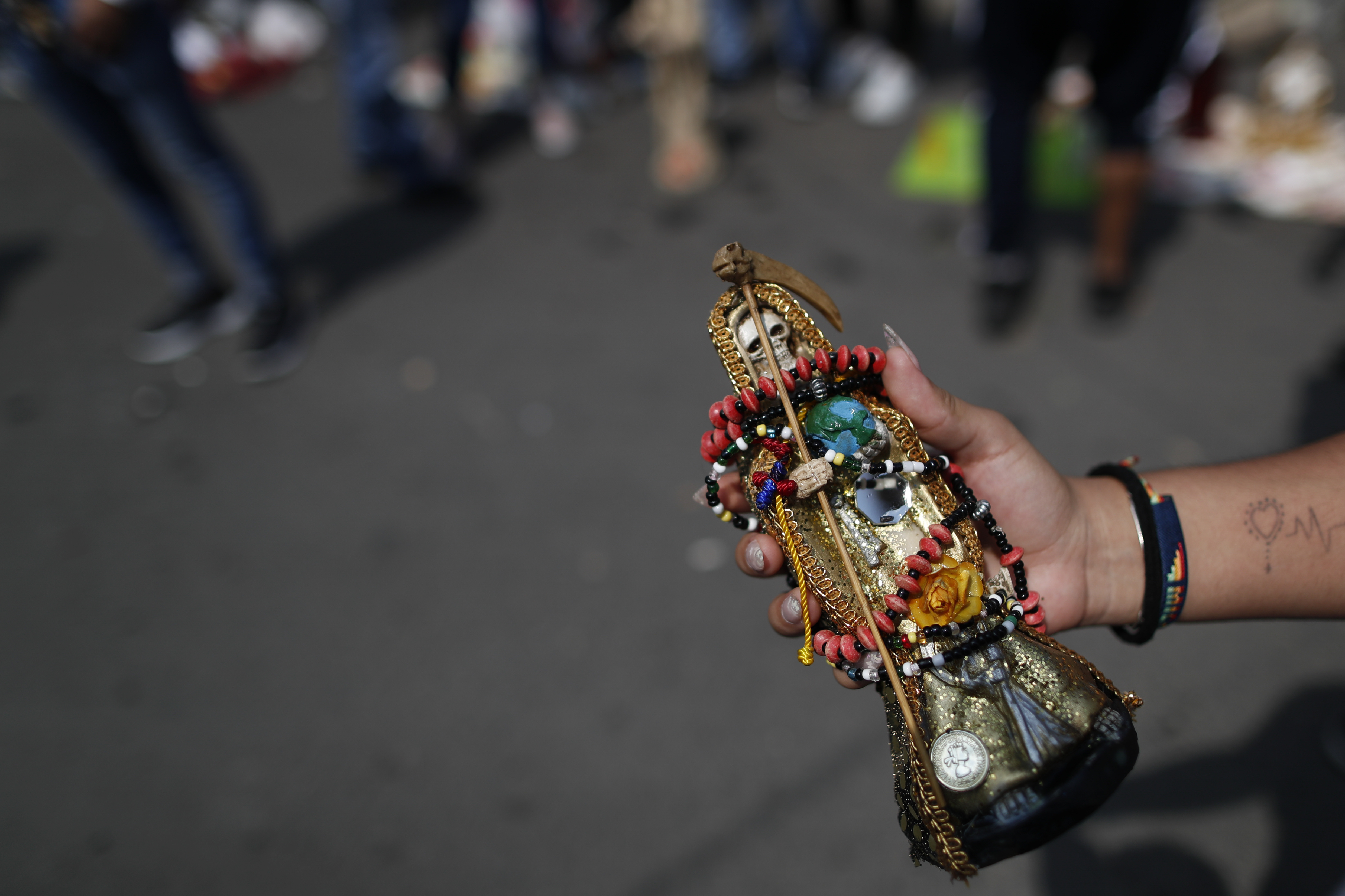 Una mujer muestra una pequeña estatua adornada de la Santa Muerte. (Foto: AP / Rebecca Blackwell)
