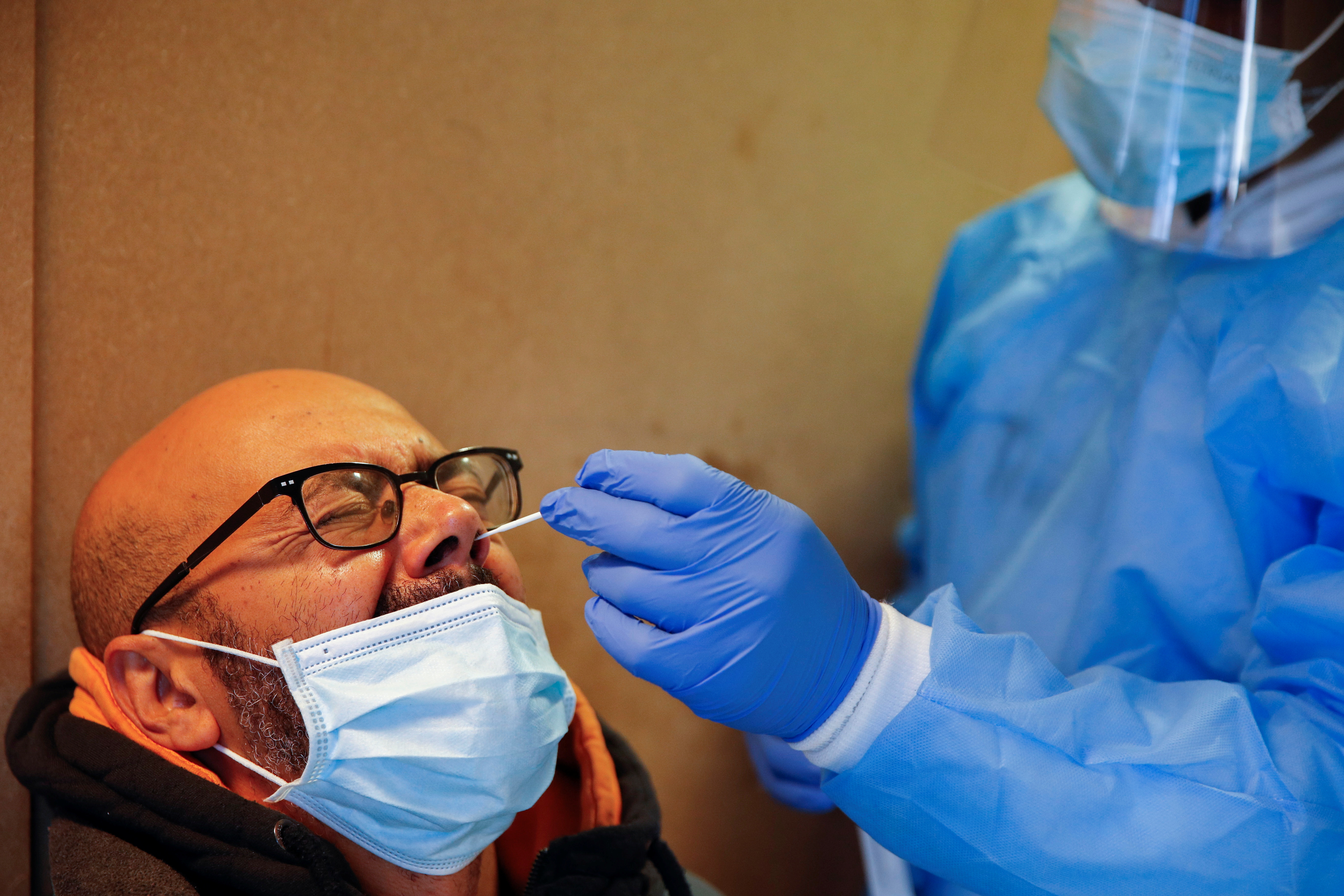 Un trabajador sanitario toma una muestra de hisopo de un hombre para analizar la enfermedad del coronavirus (COVID-19) en un centro de análisis en Bruselas, Bélgica, el 27 de noviembre de 2021. (REUTERS/Johanna Geron)